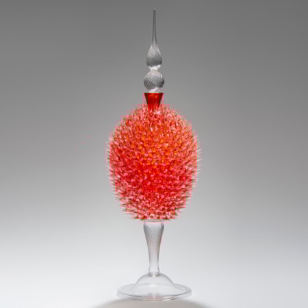 glass sculpture of spiked orange ball in the centre of clear glass base and top