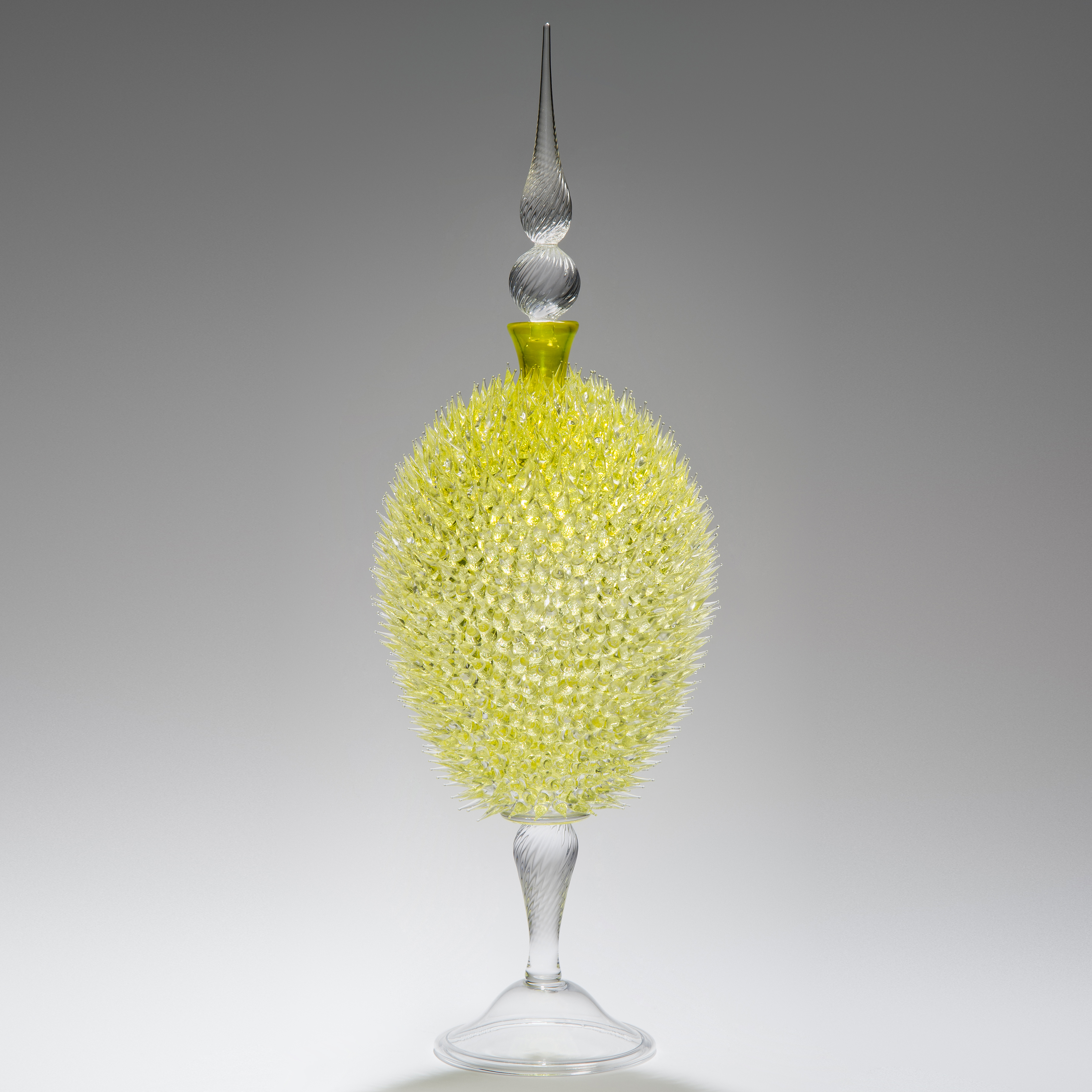 glass sculpture of spiked yellow ball in the centre of clear glass base and top