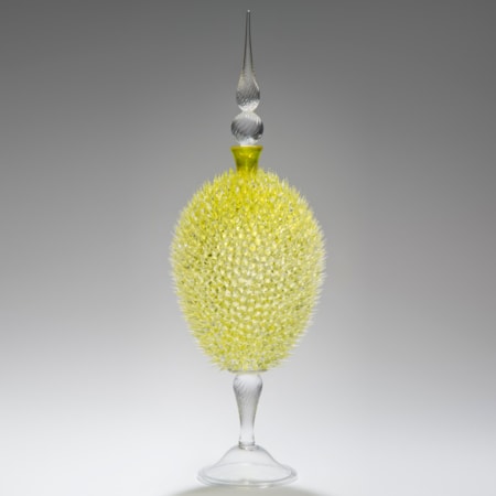 glass sculpture of spiked yellow ball in the centre of clear glass base and top