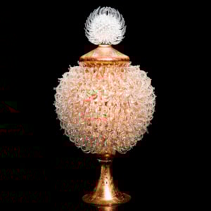 pink bronze glass sculpture of round jar atop cone shaped base with white thistle top