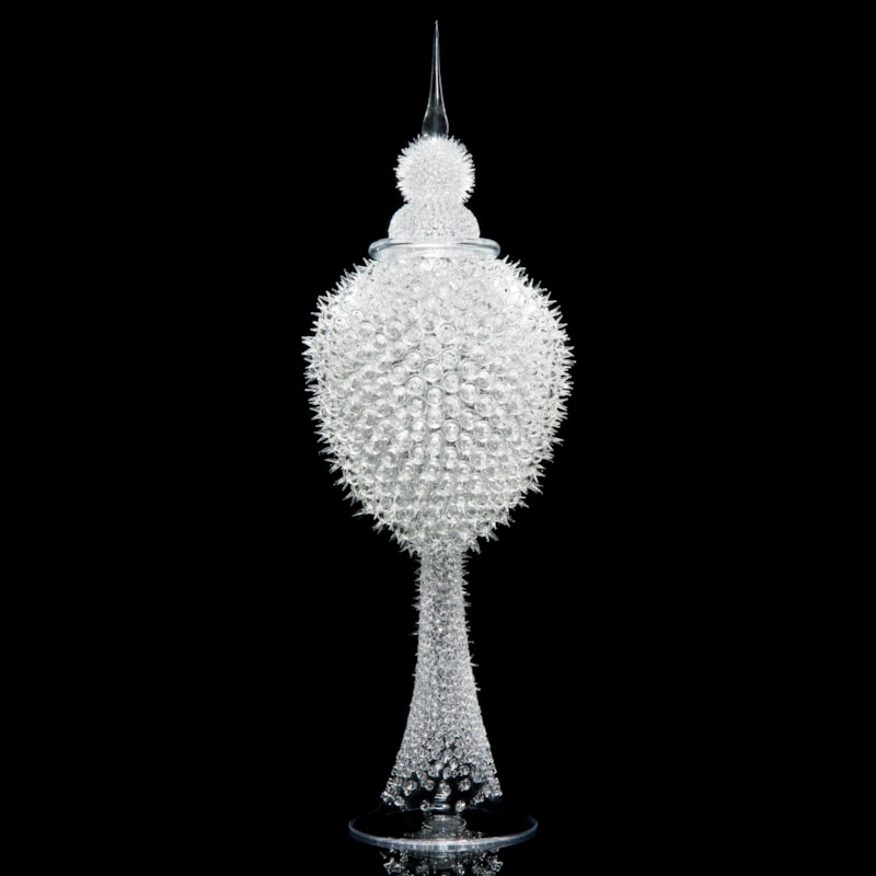 tall white glass sculpture of rounded prickly blobs on long cone with pointed top