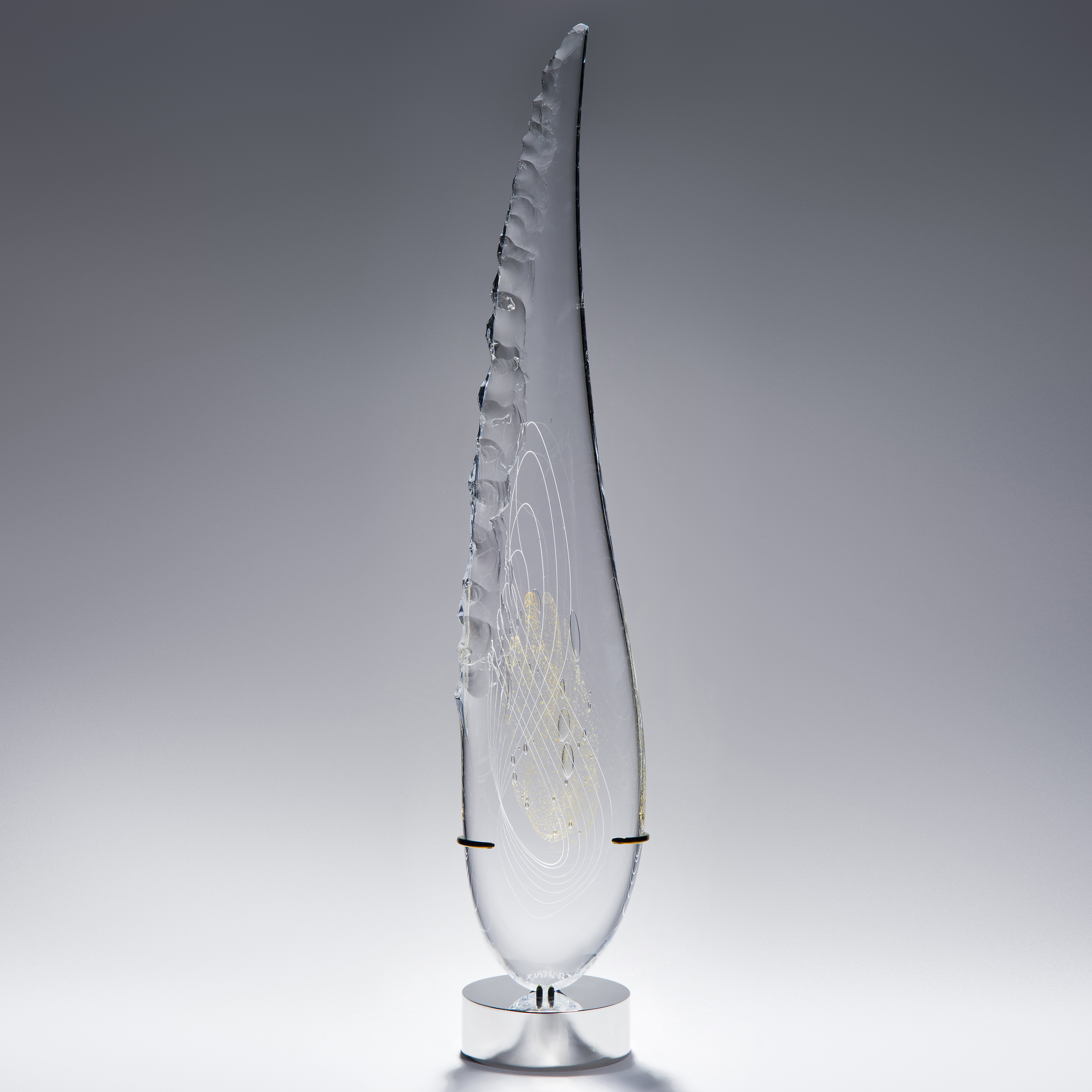 tall thin black art glass sculpture in the shape of a feather with hand chipped exterior gold patterns