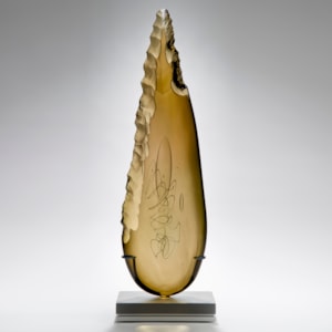 bronze leaf shaped art glass sculpture on grey base