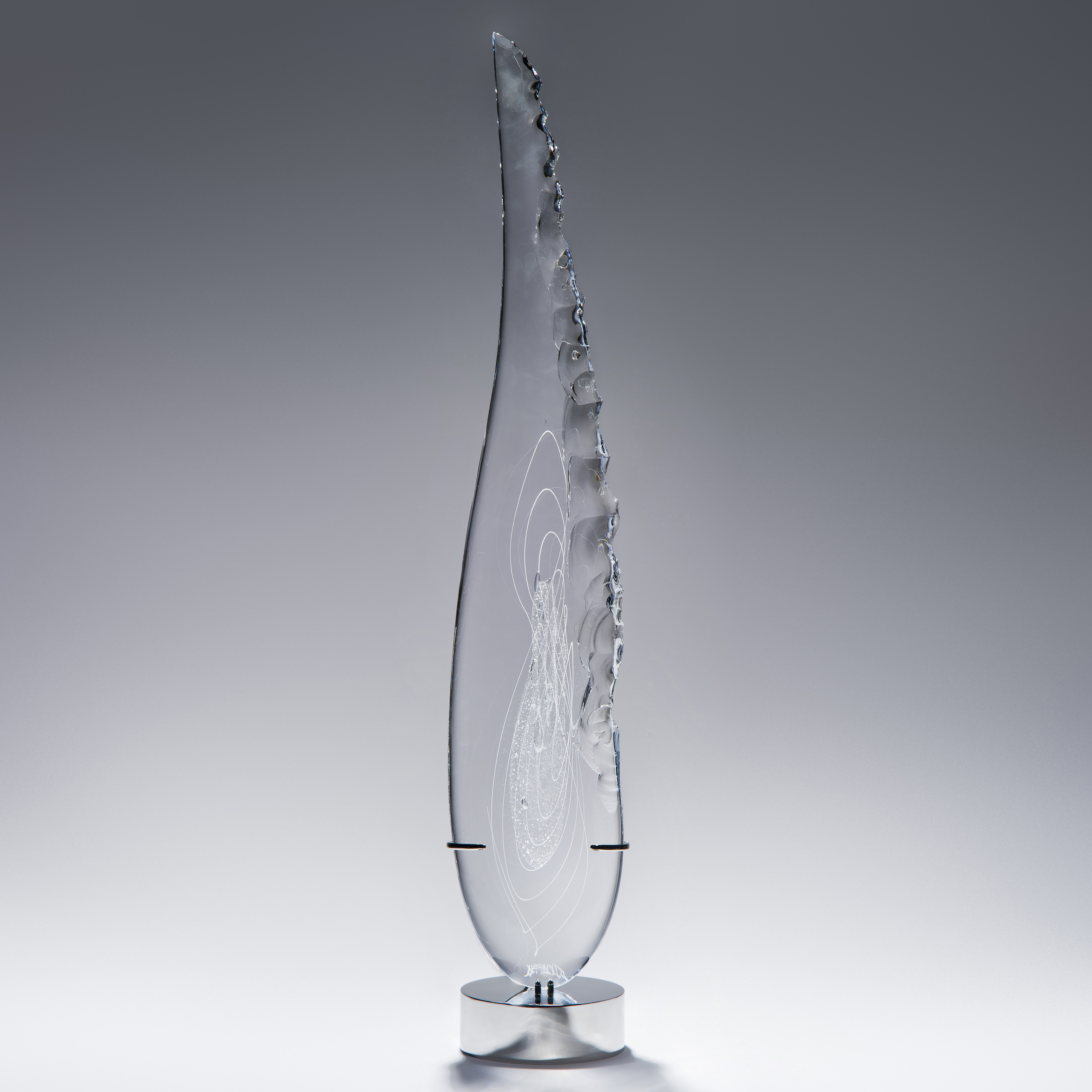 tall thin black art glass sculpture in the shape of a feather with hand chipped exterior patterns