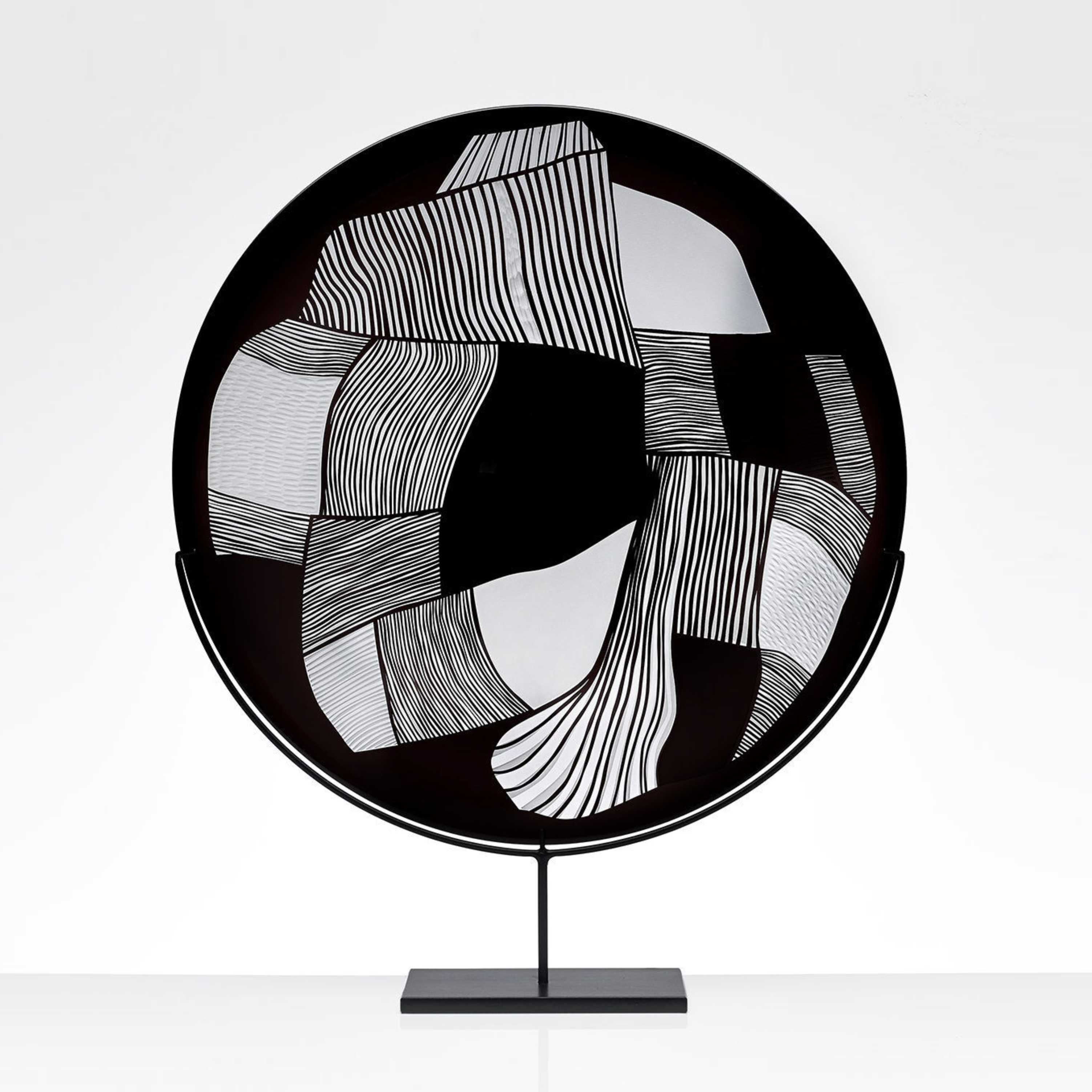 round modern glass art sculpture in black and white on steel stand