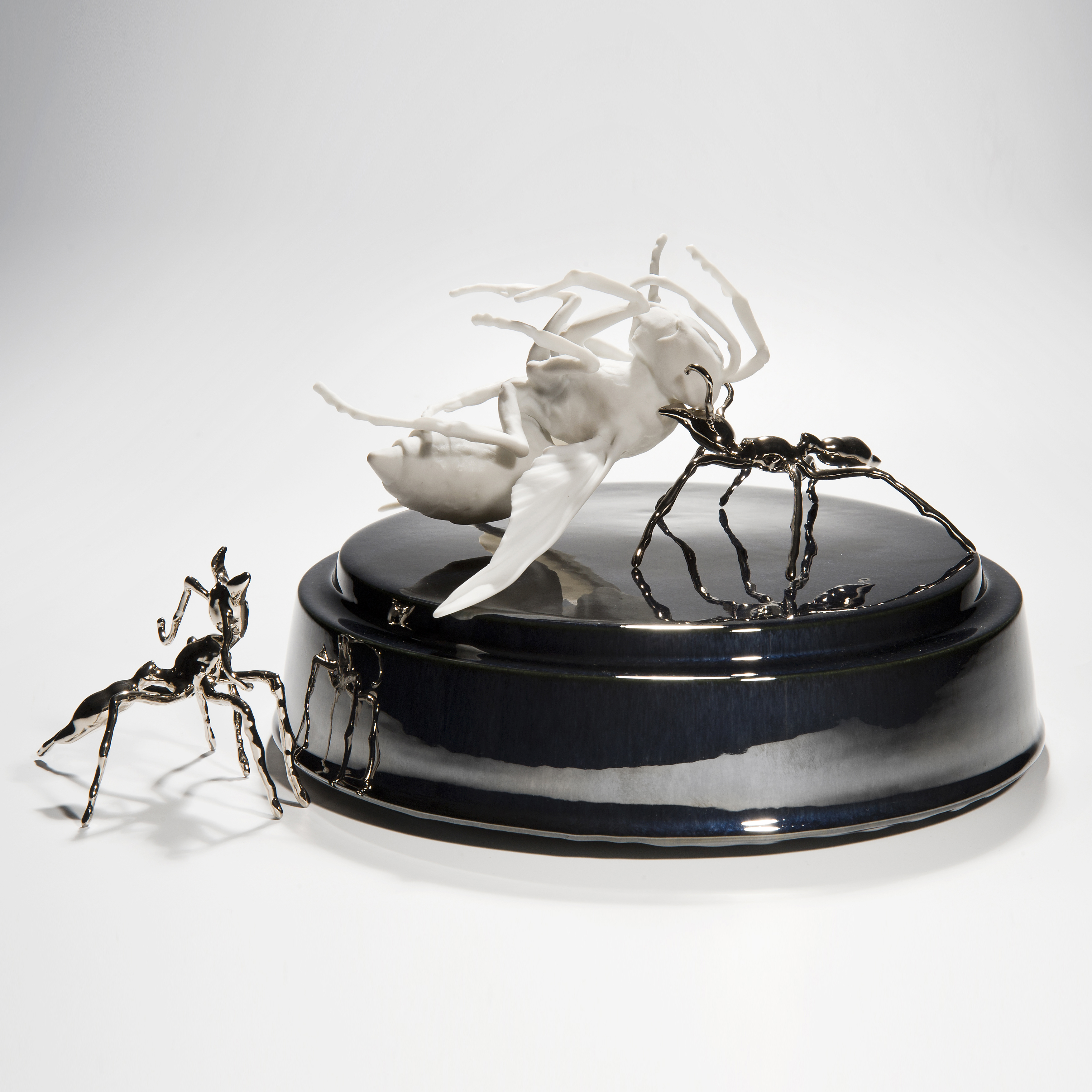 ceramic and metal sculpture of hornet and ants on round base