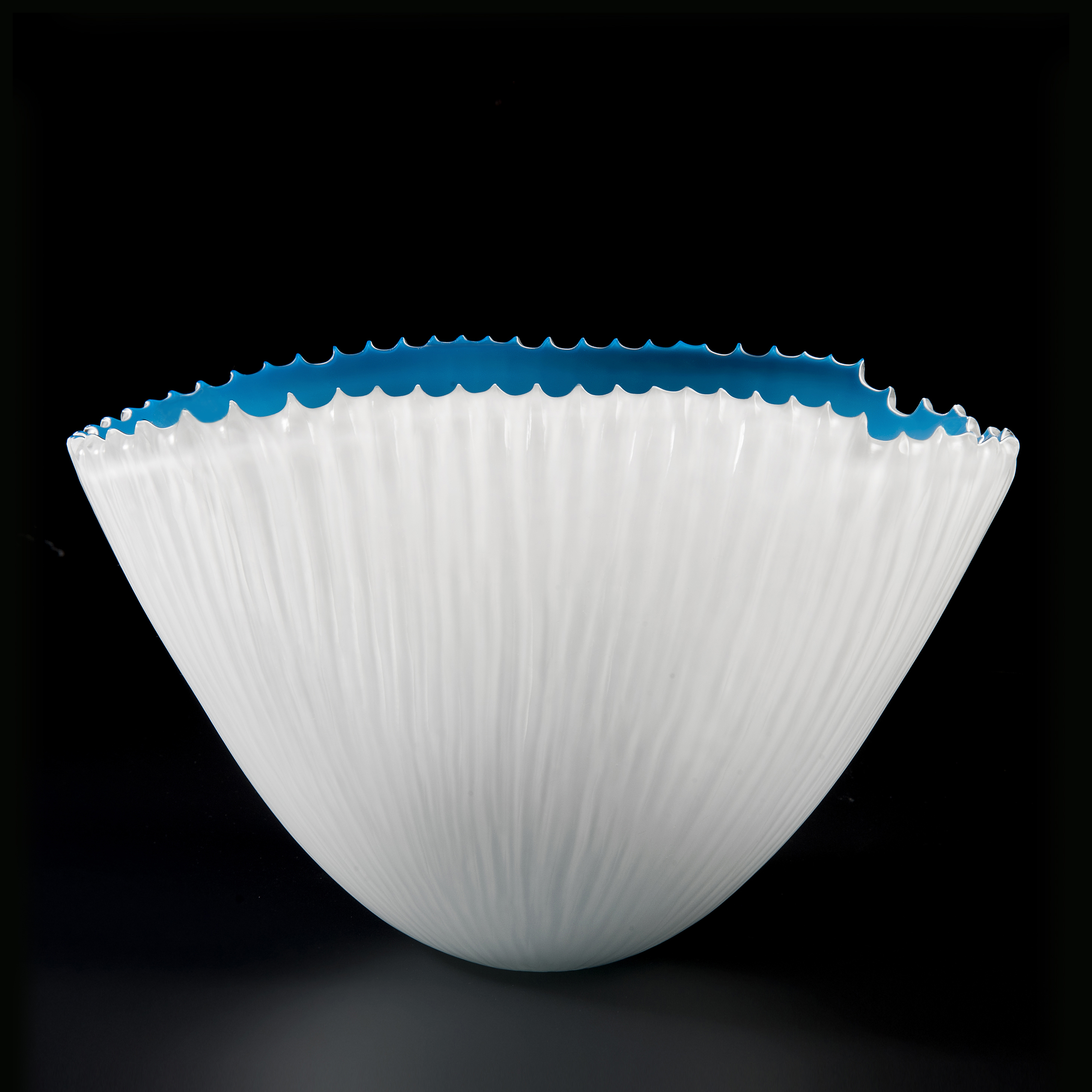 decorative hand cut art glass bowl with white exterior and blue interior 