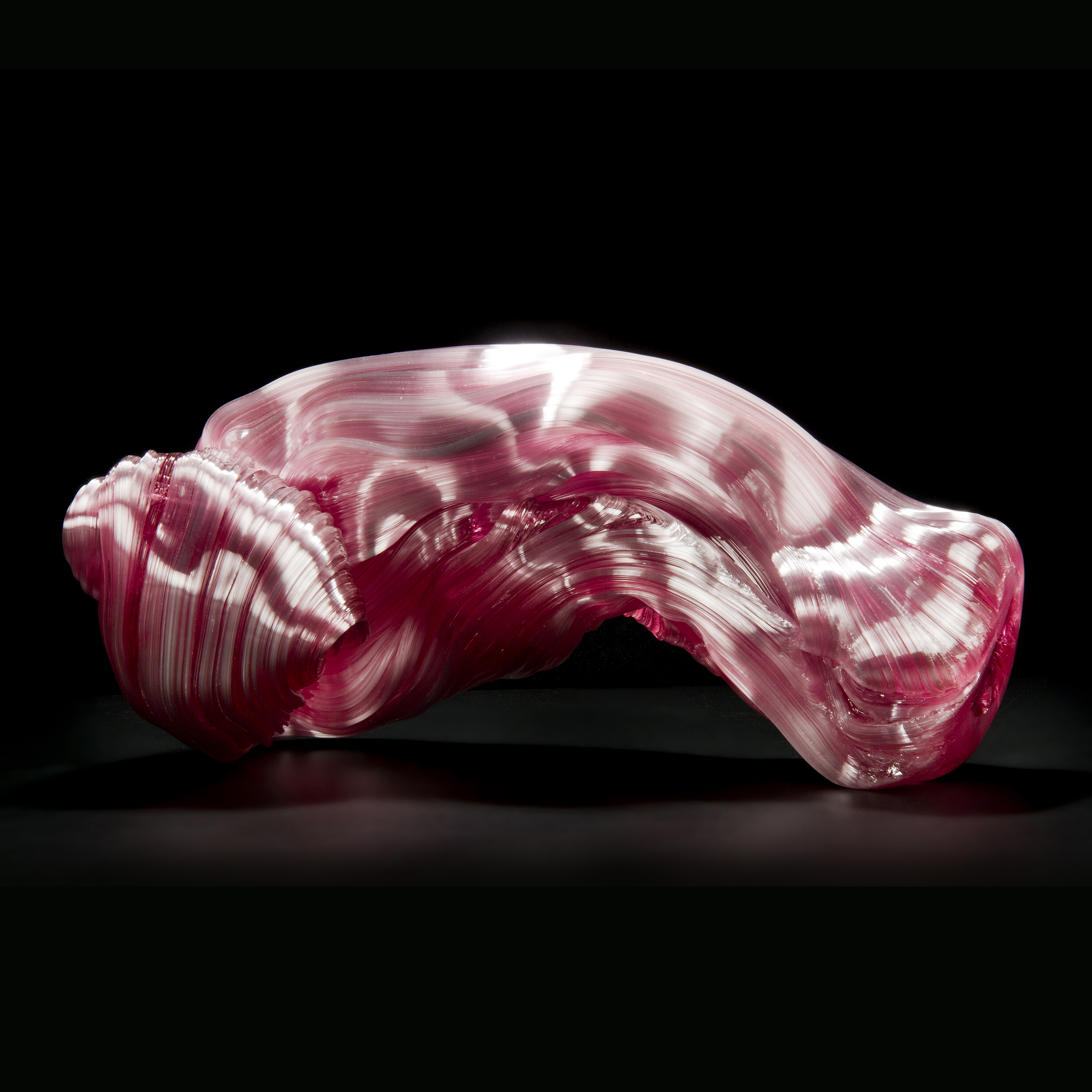 stretched and bent glass formation of abstract sculpture in pink