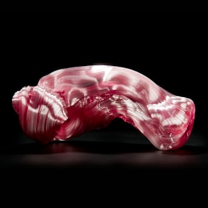 stretched and bent glass formation of abstract sculpture in pink