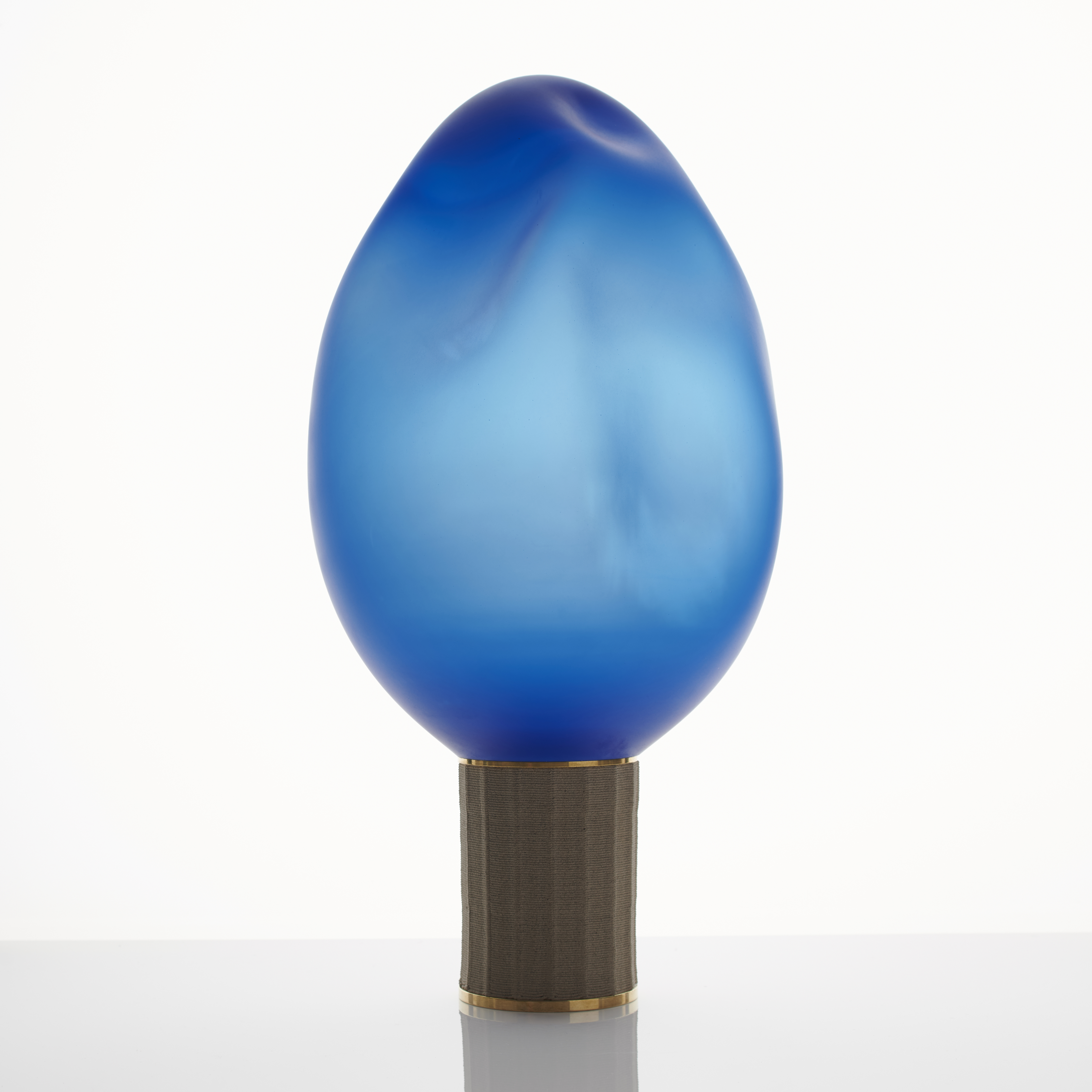 contemporary art glass sculpture resembling lightbulb of blue oval shaped top resting on bronze base