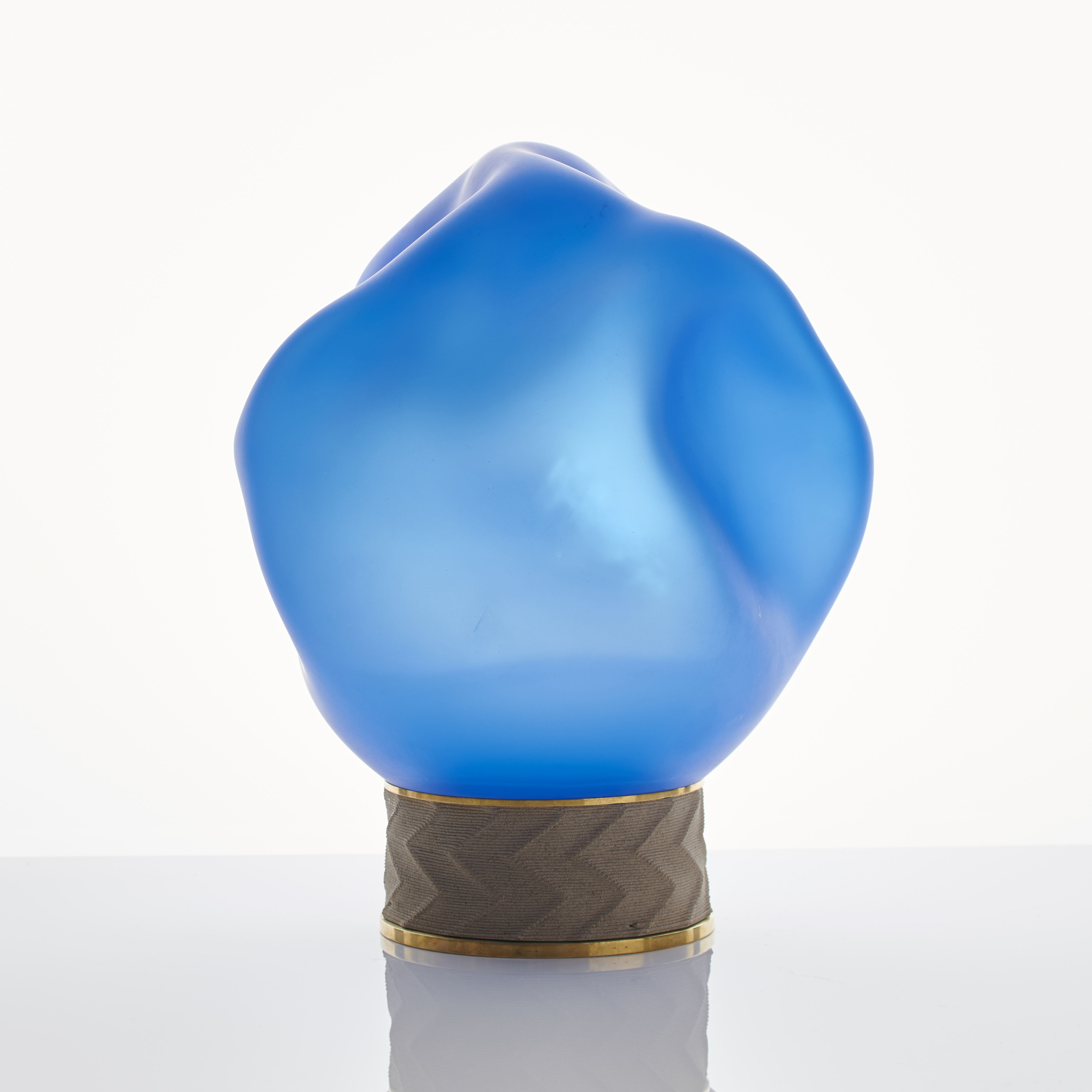 blue art glass sculpture of blob shaped blown glass top with bronze base
