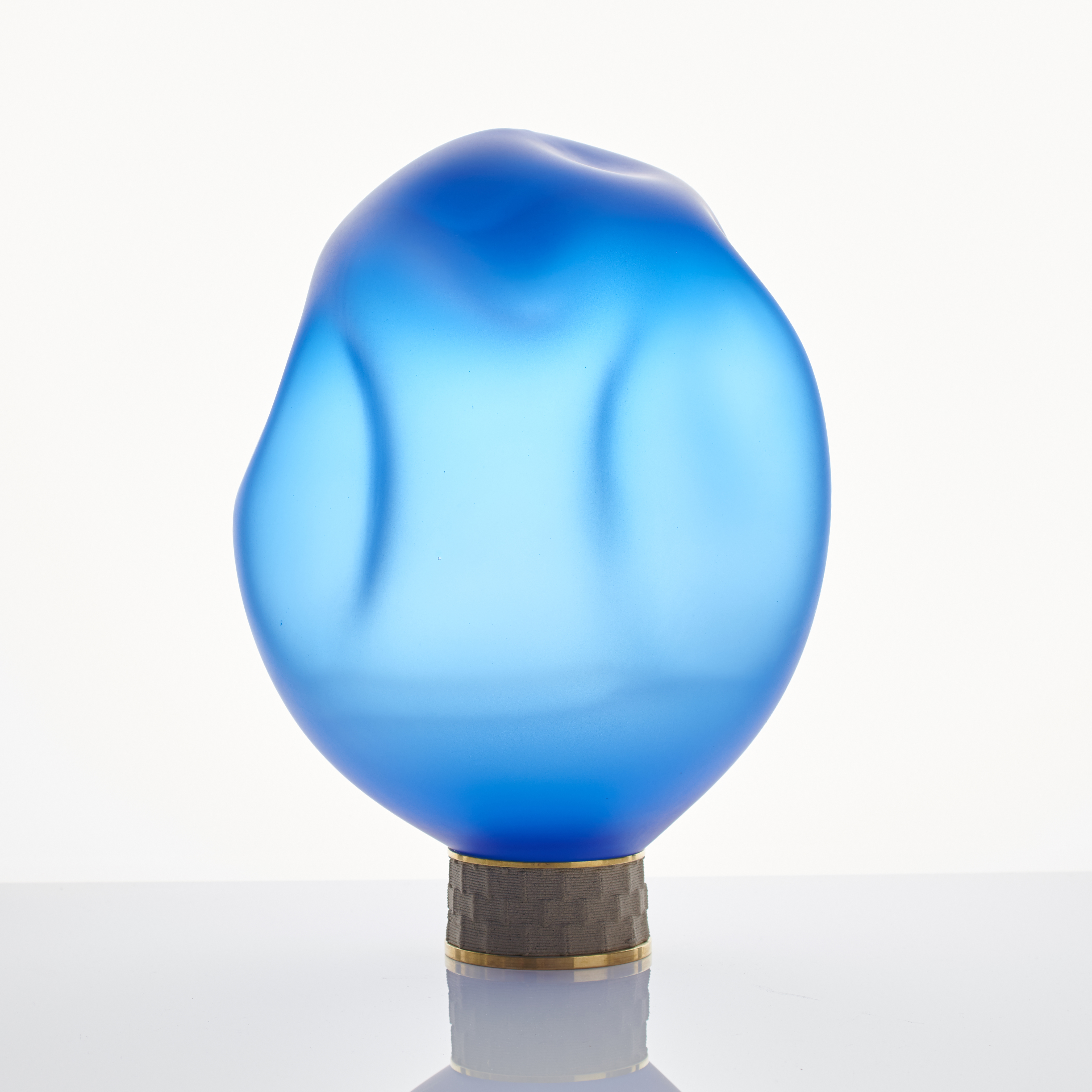 blue art glass sculpture of blob shaped blown glass top with bronze base