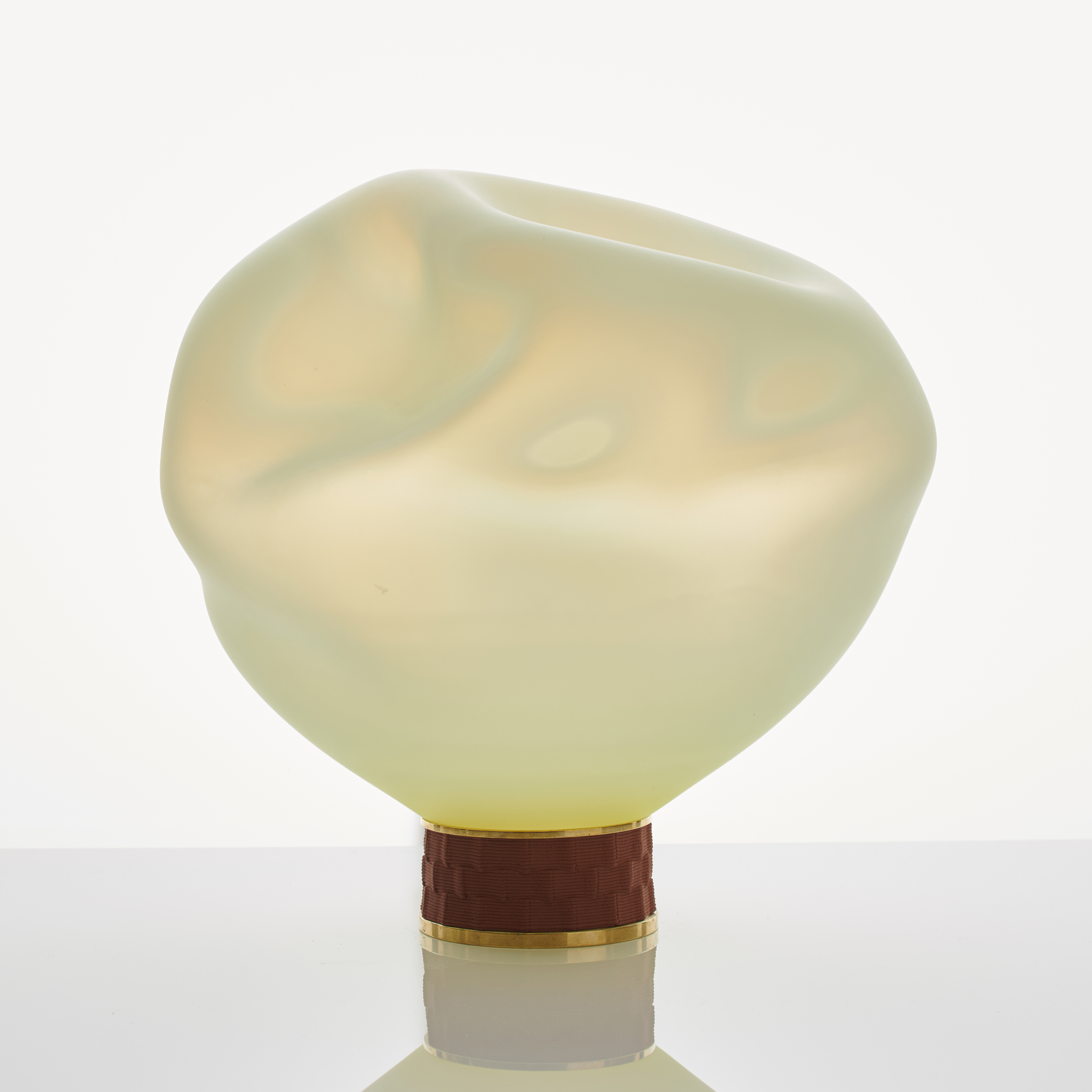 cream art glass sculpture of blob shaped blown glass with bronze base