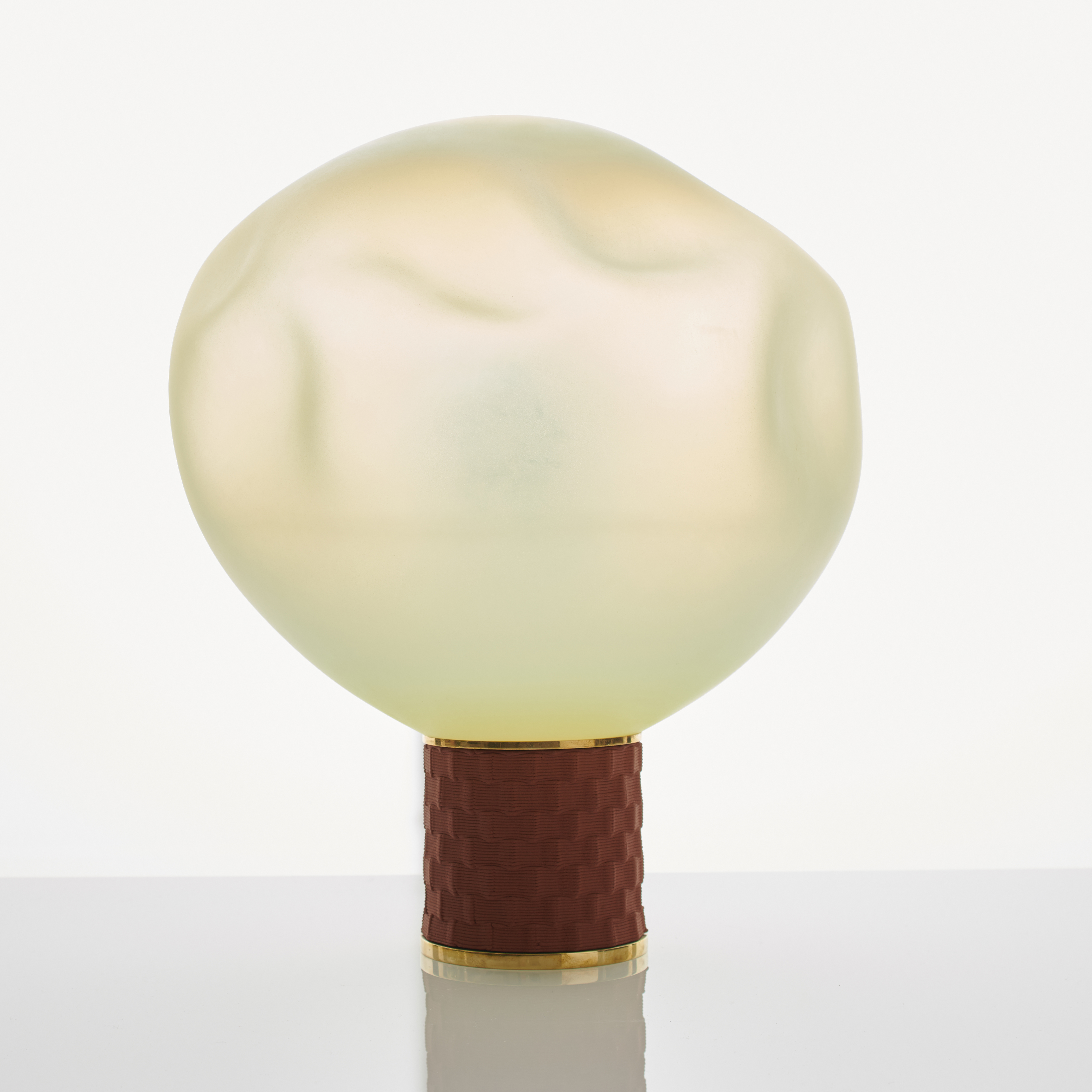 cream art glass sculpture of blob shaped blown glass with bronze base