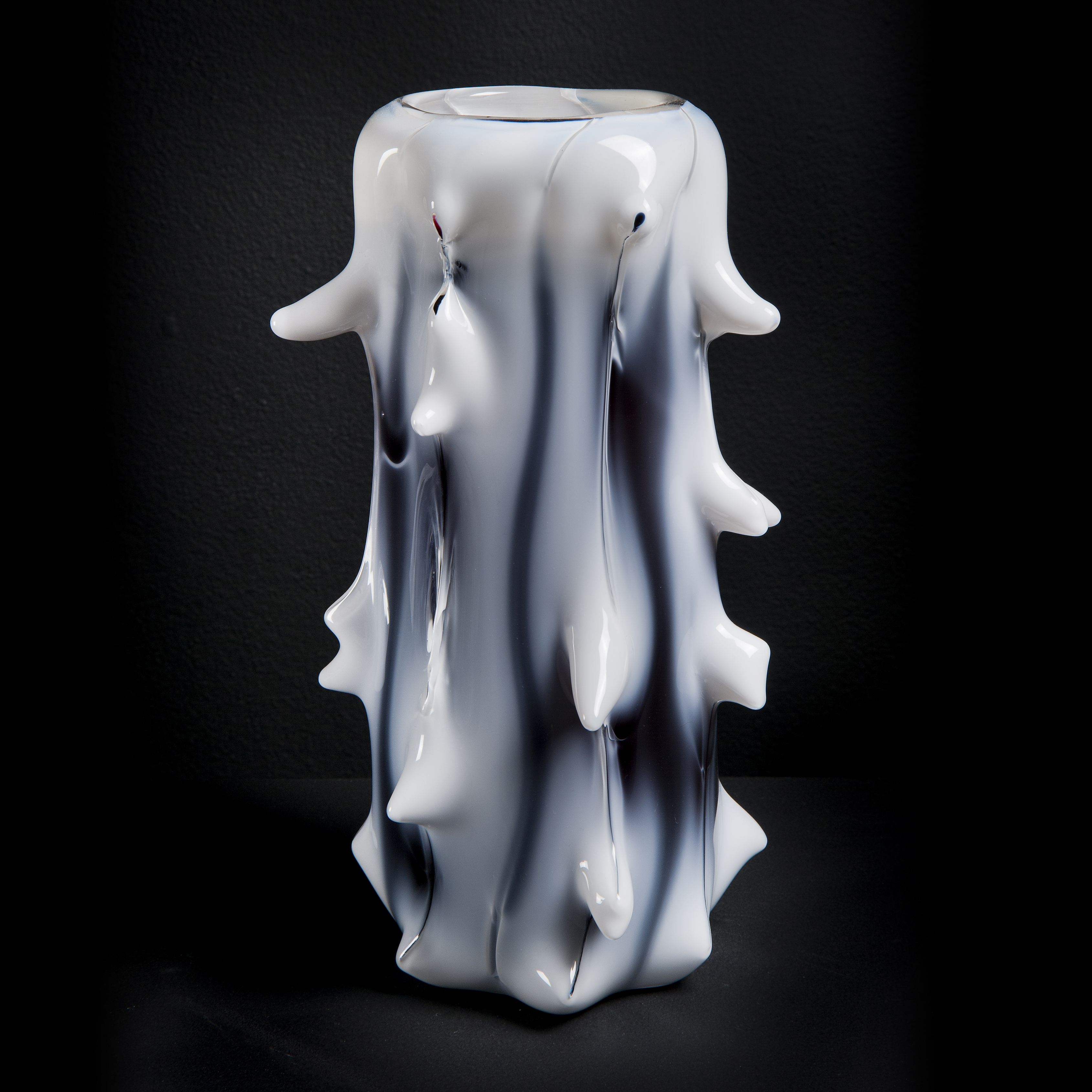 tall white abstract glass sculptre with random protruding scale-like edges and black shading