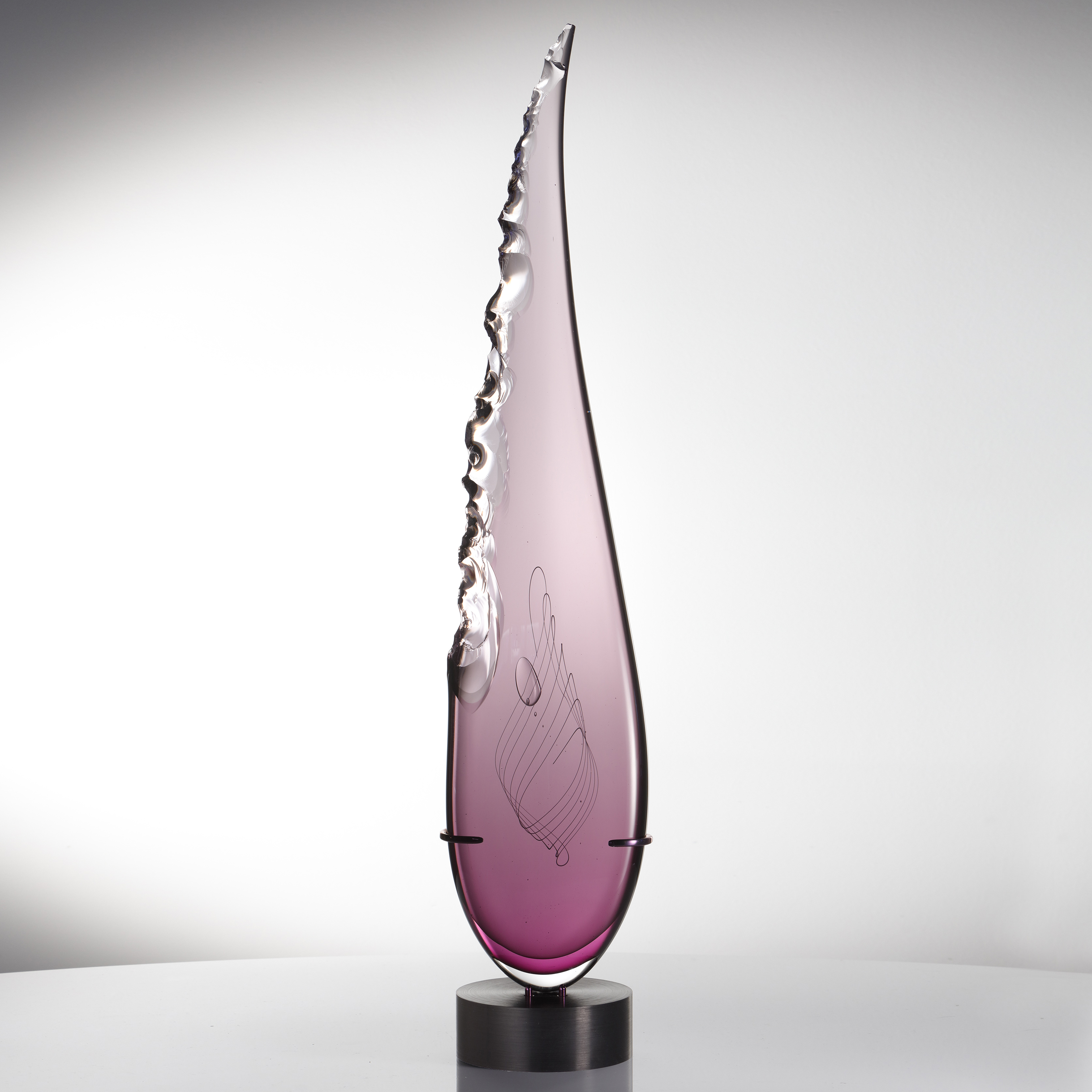 sculpted pink glass in upright feather shape resting on black metal base