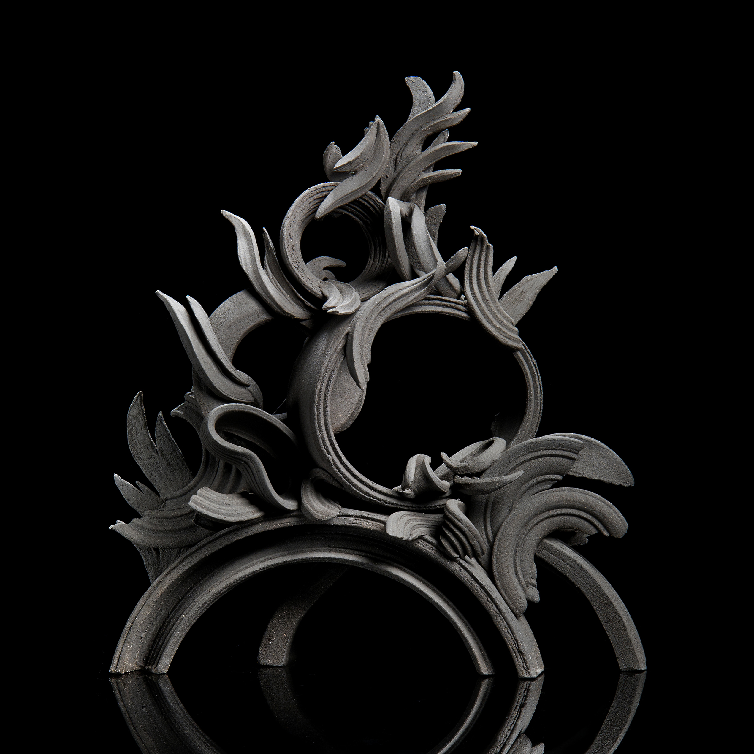black stoneware sculpture in classical style with arcs and flares