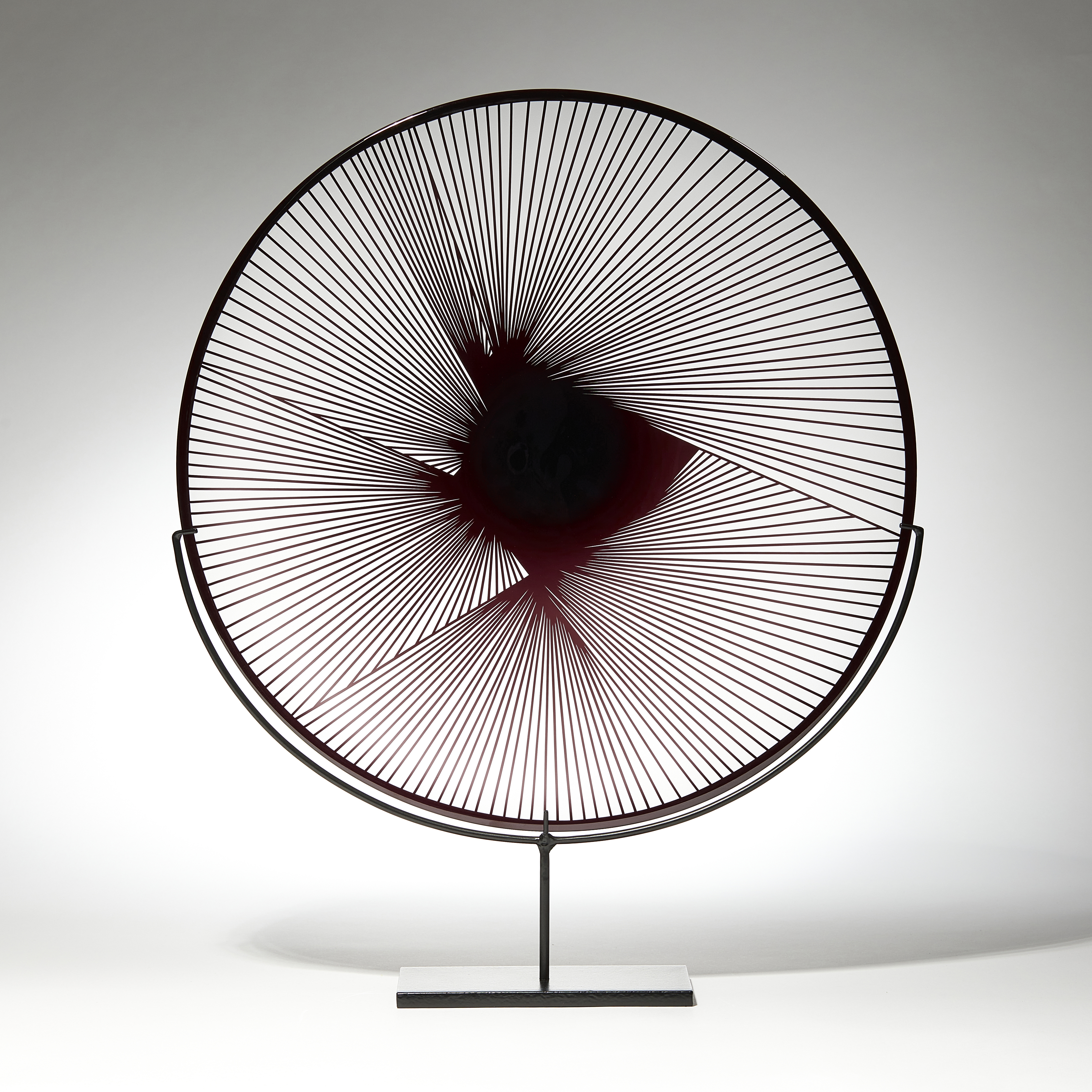 clear and black plate with graphic raised cutting detail on a black stand