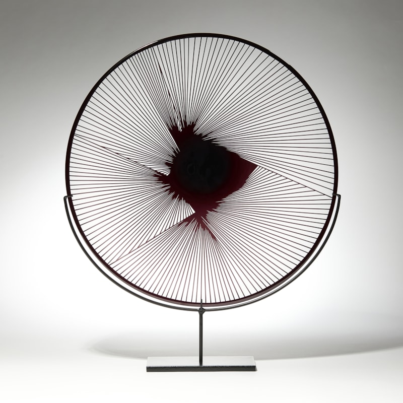 clear and black plate with graphic raised cutting detail on a black stand