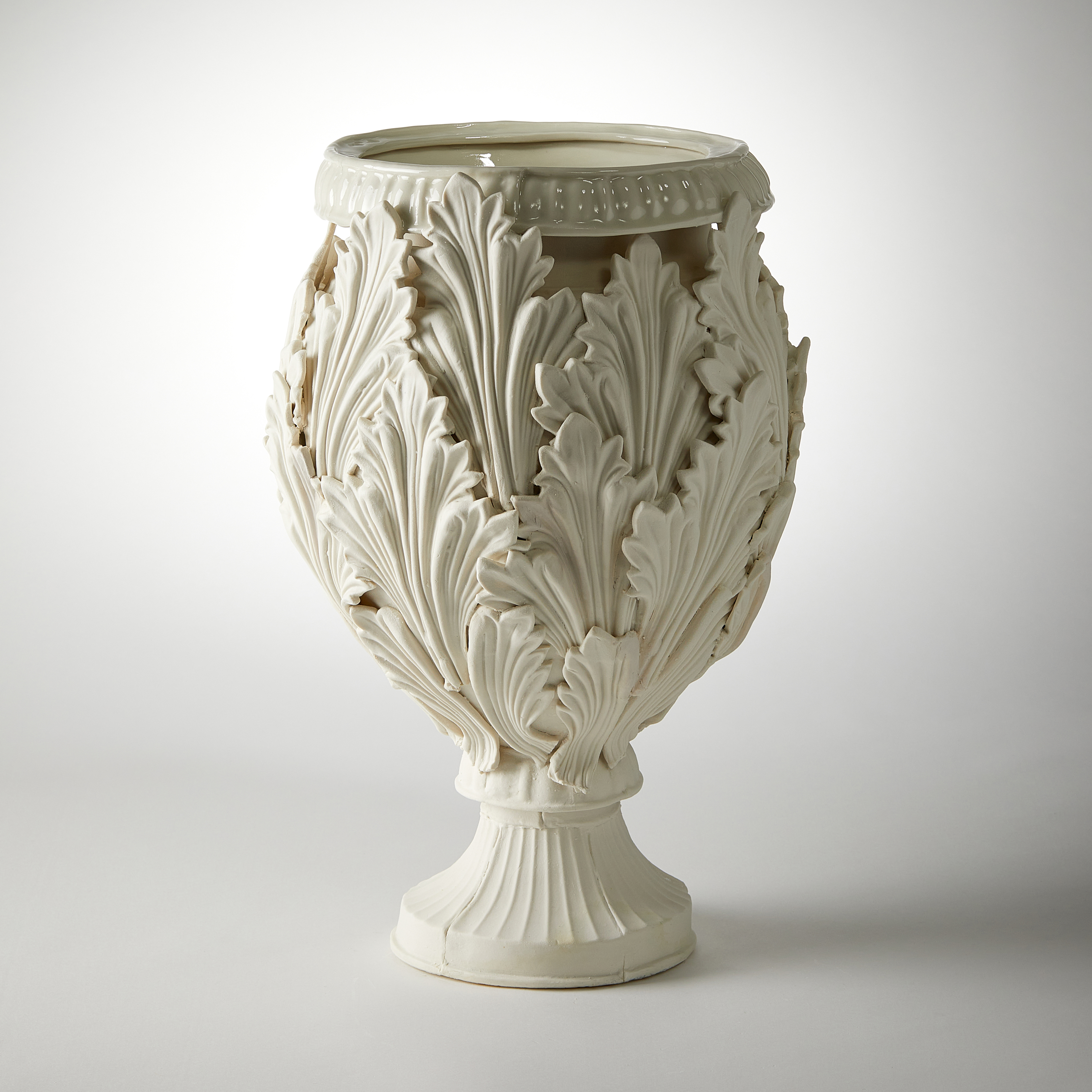 footed ornate vessel with leaf decoration handmade from porcelain