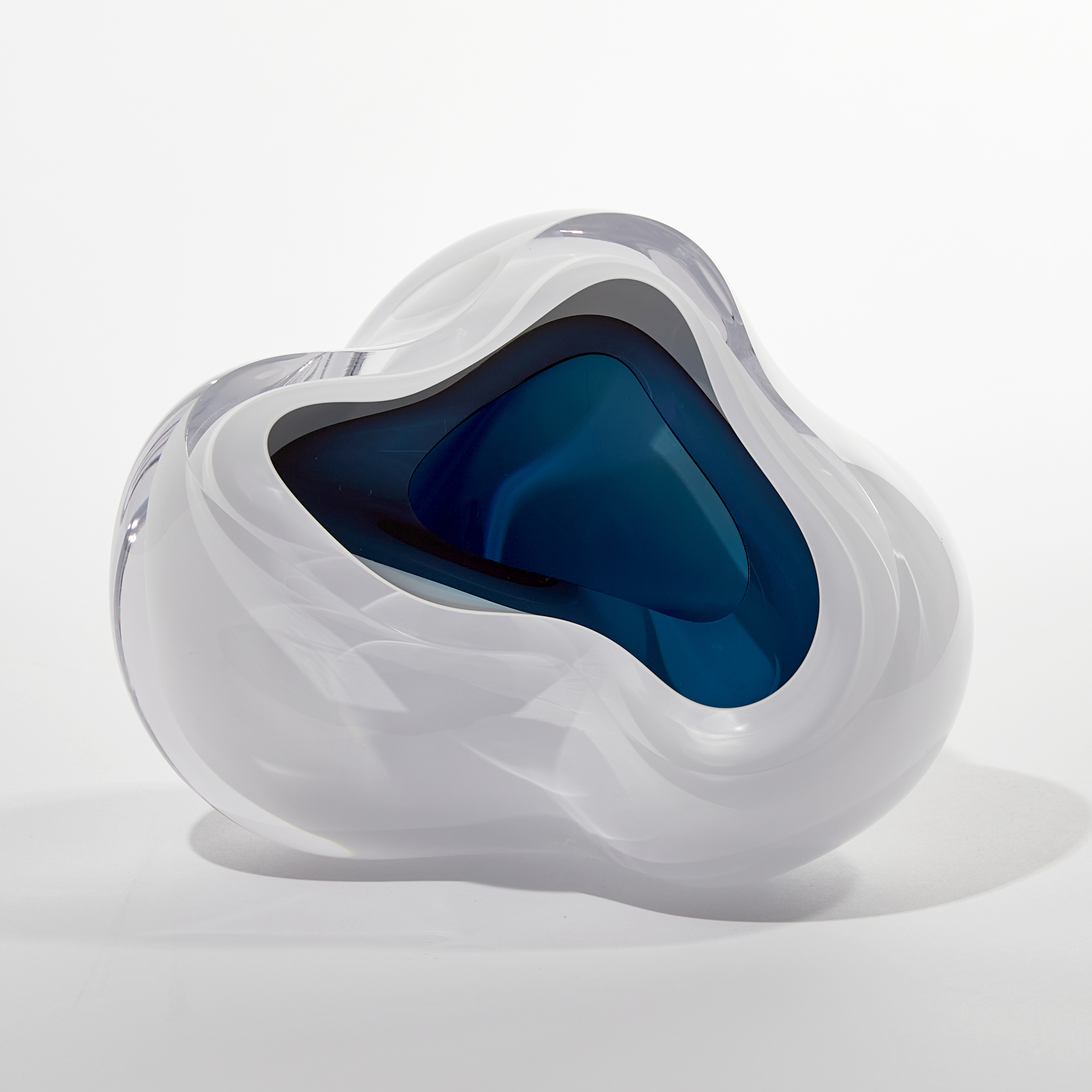 cloud like soft white form with blue interior handmade from blown glass