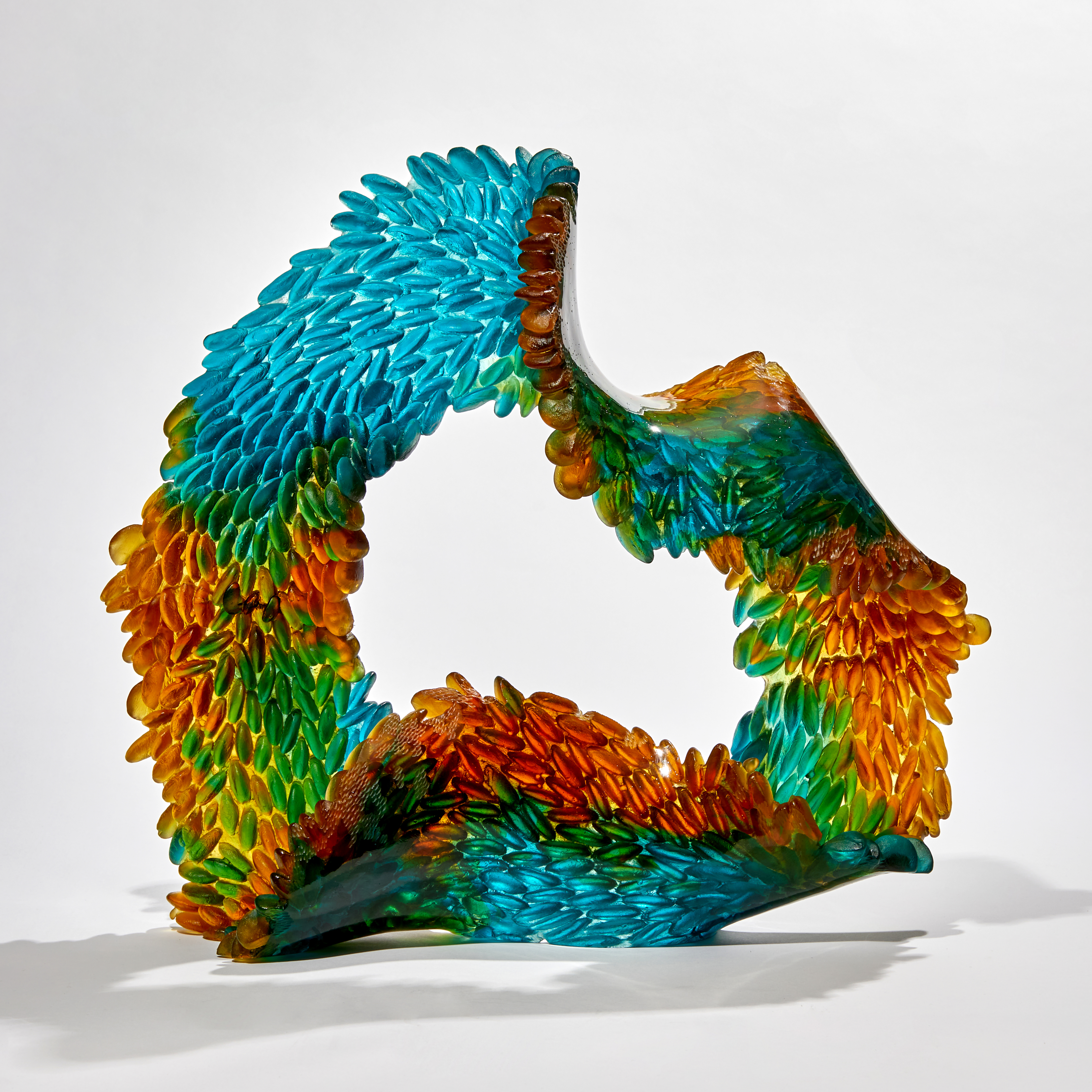 green turquoise and amber continuous ringed scaled sculpture made from glass