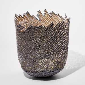ornamental vessel in black and gold made from steel and precious metals