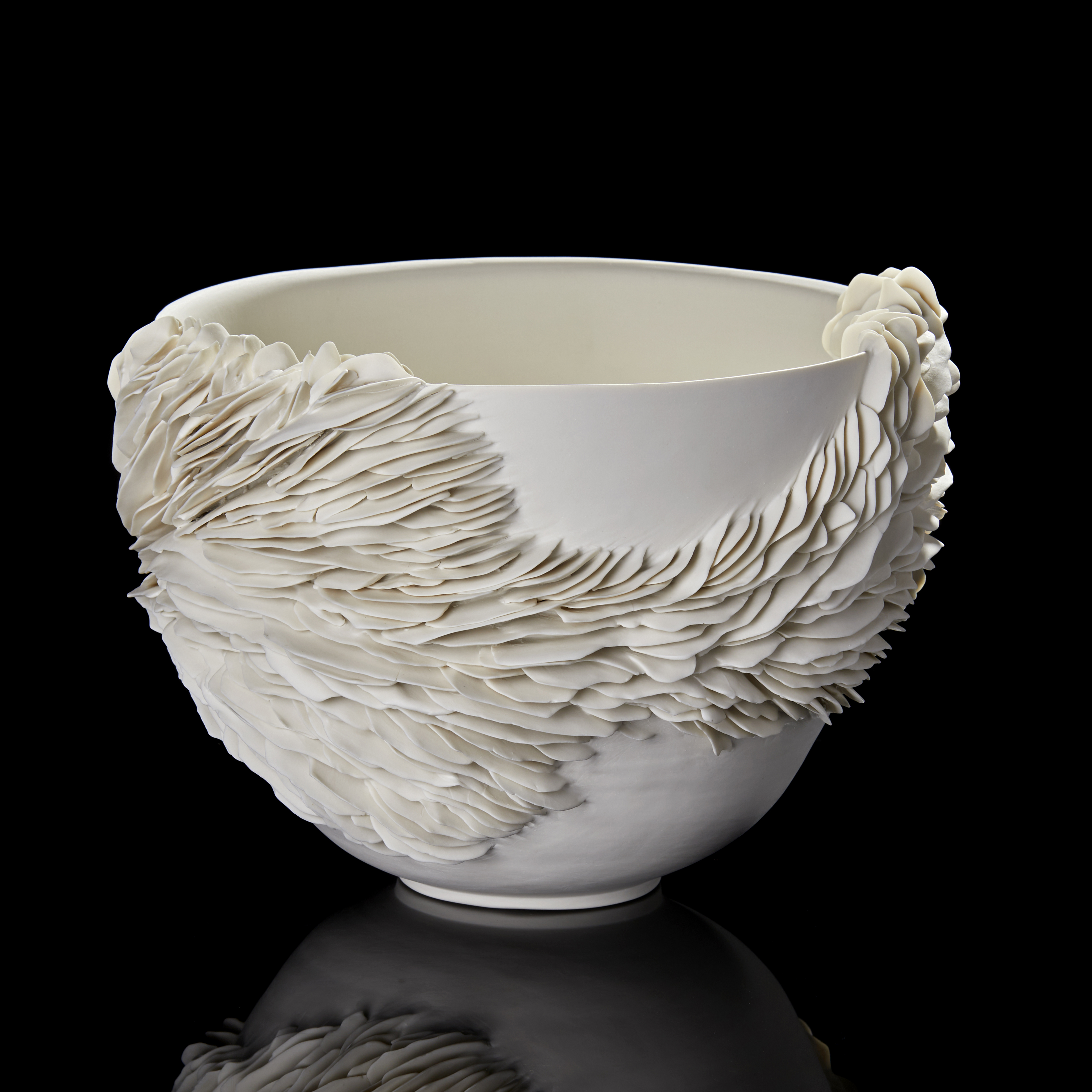 white deep wide bowl with the exterior partially covered in organic fins and ridges handmade from porcelain