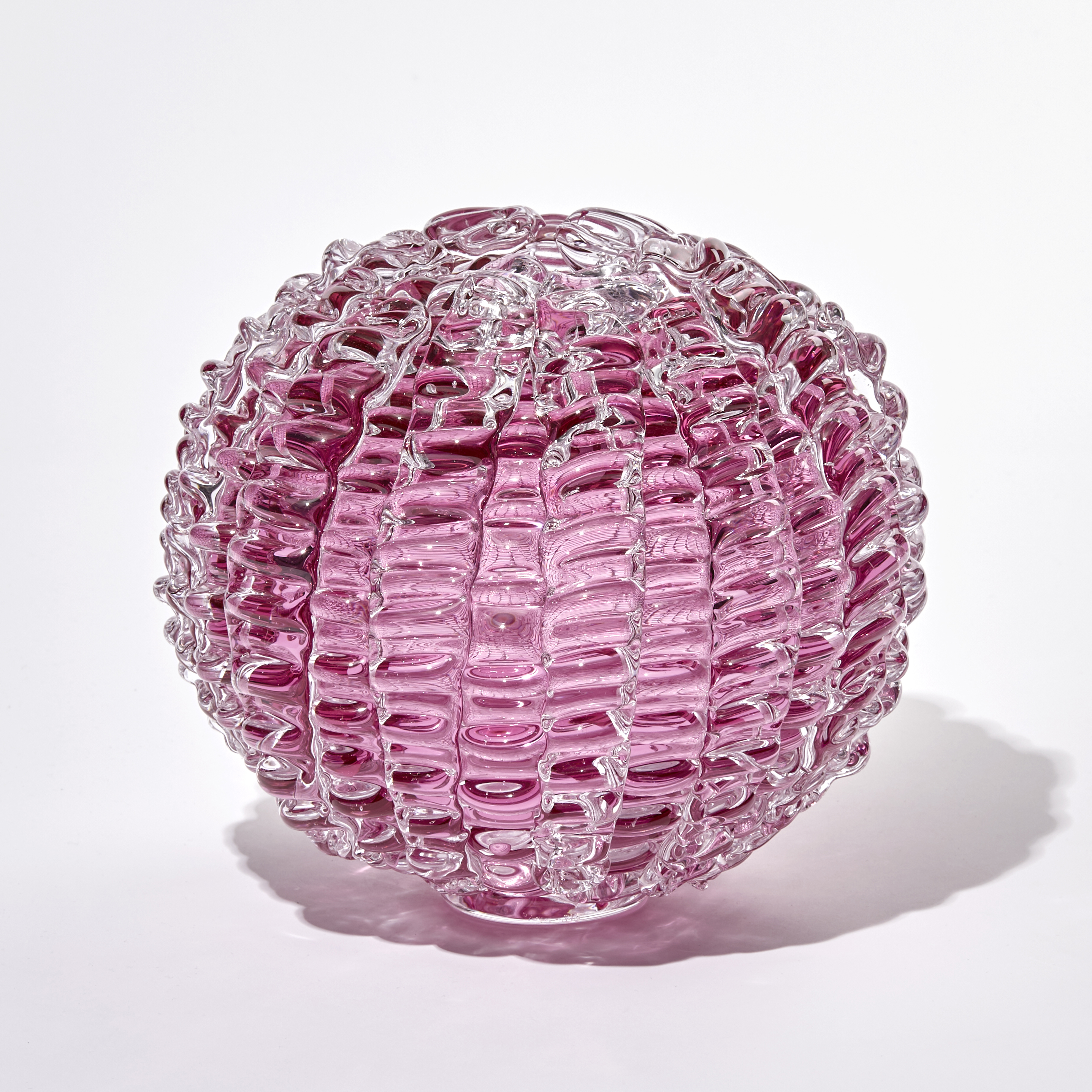 pink ridged globe shaped sculpture handmade and sculpted from glass with small top opening