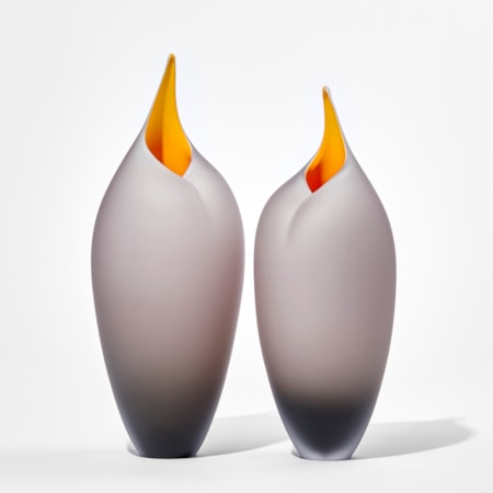 two bronze grey sleek tall rounded bird forms with pointed open beak with yellow interiors