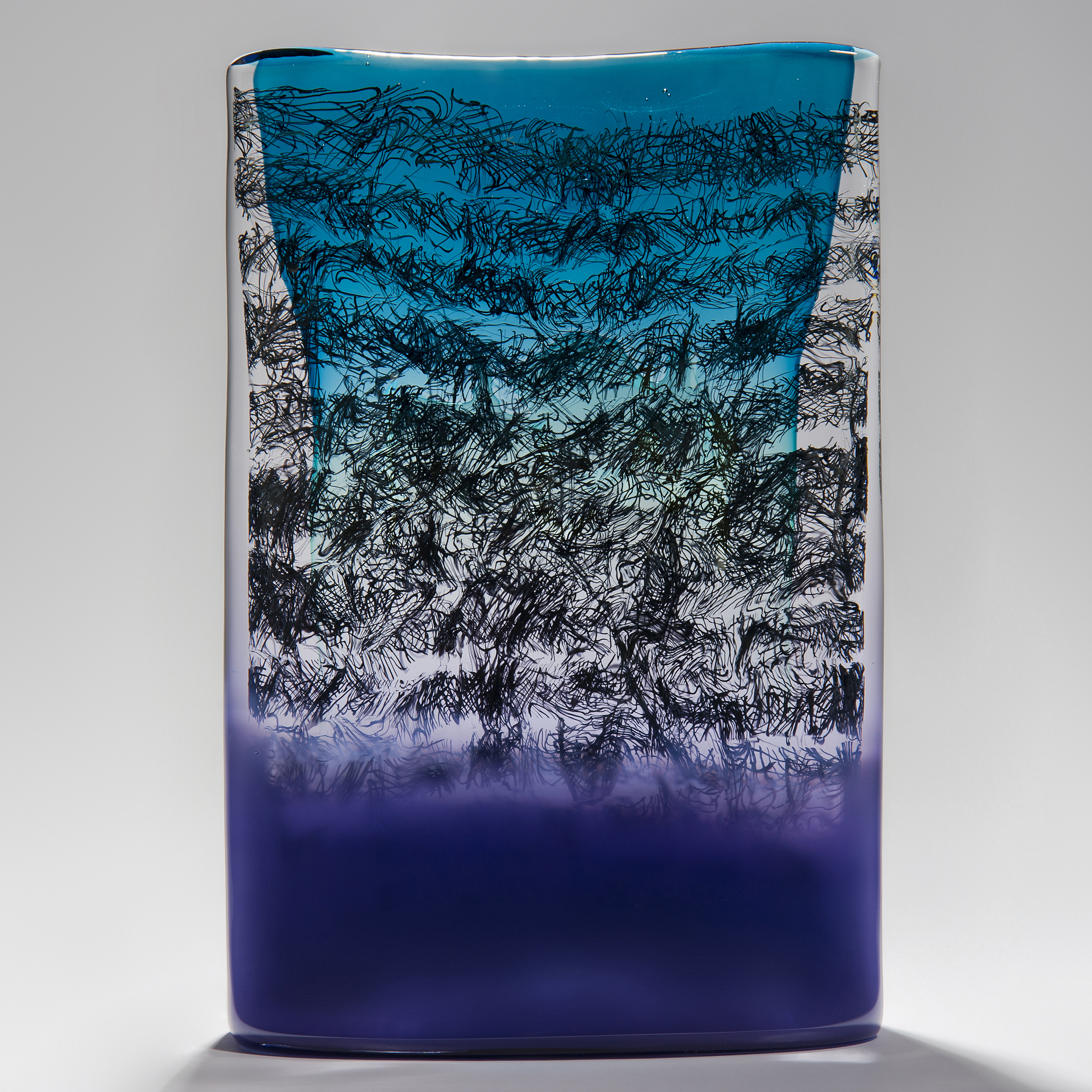 blue clear and purple tablet shaped handmade glass sculpture with black messy script