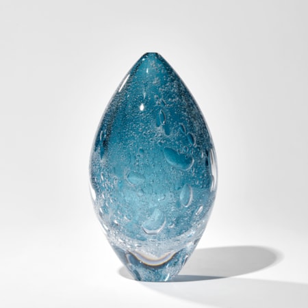 fading rich blue ovoid sculpture with internal bubbles hand made from glass