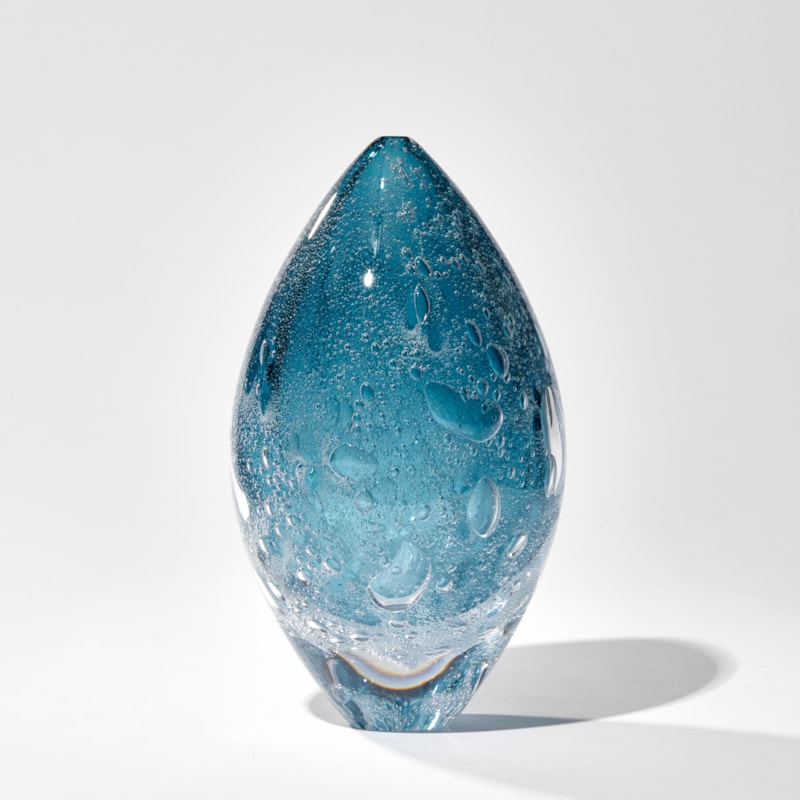 fading rich blue ovoid sculpture with internal bubbles hand made from glass