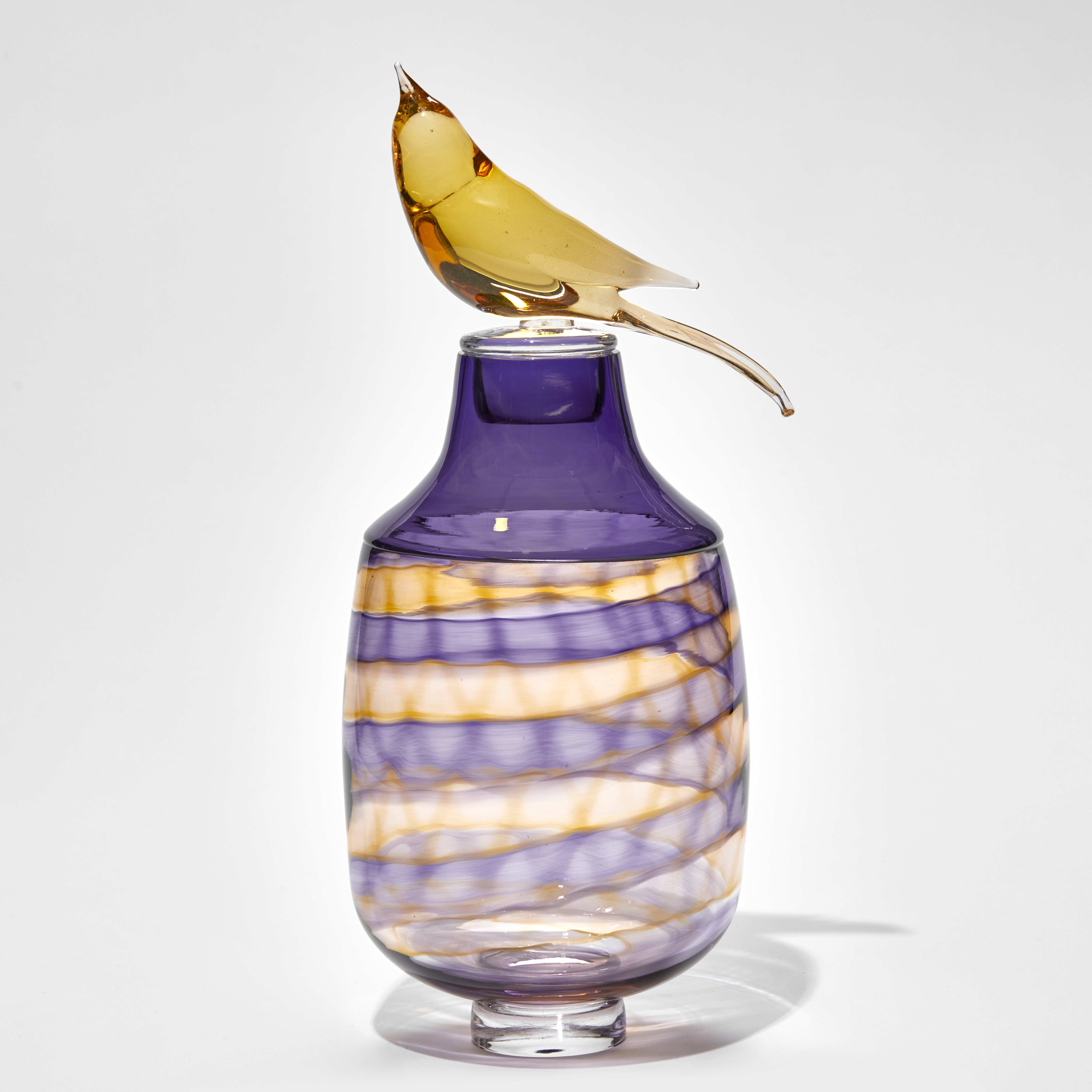 purple and bronze jar with swirling pattern and stopped with perched bird hand made from glass