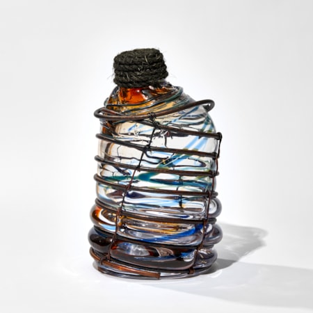 blue and amber transparent aged glass rum bottle formed in a copper cage with rope stopper hand made