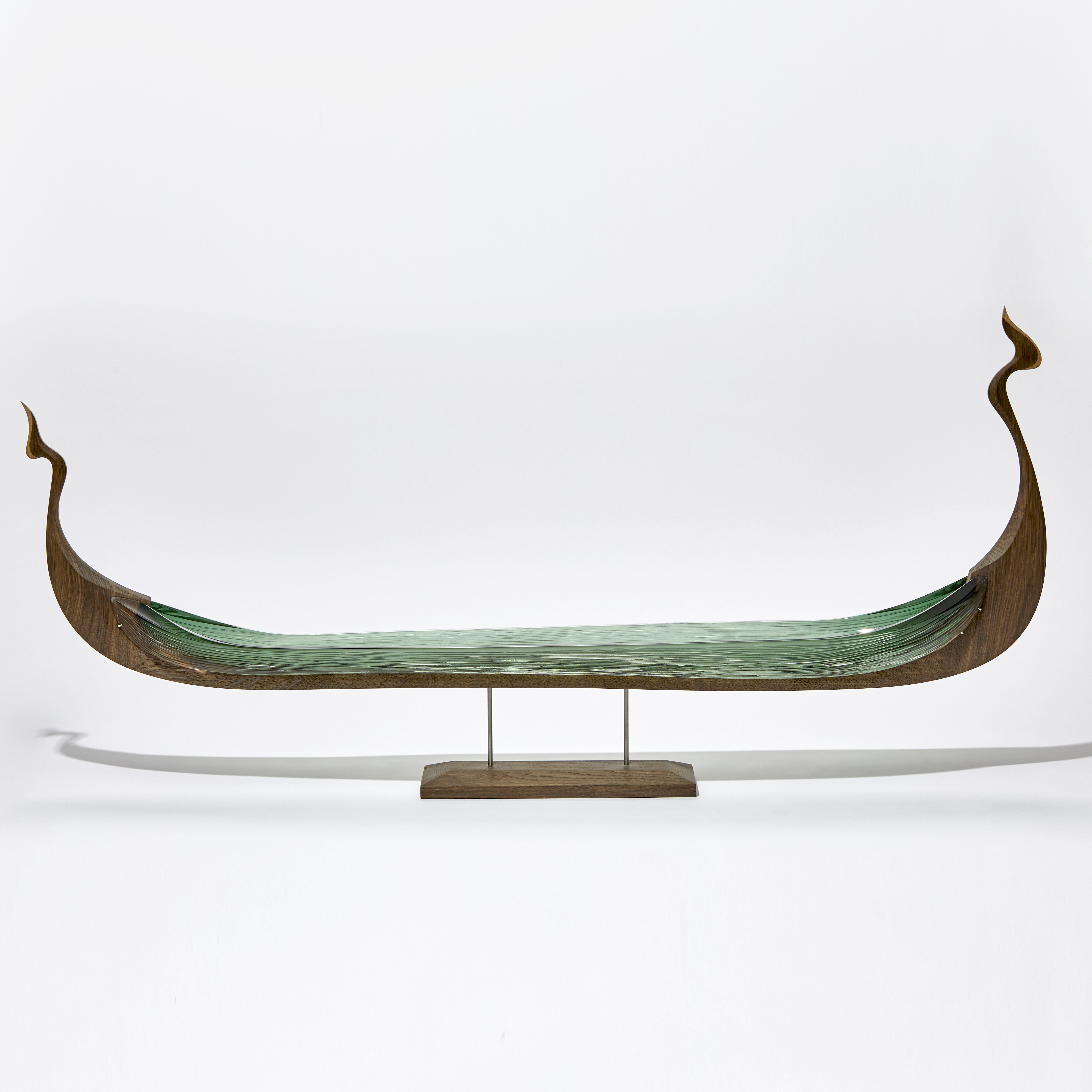 wood and glass sculpture of viking ship in green and brown on wooden base