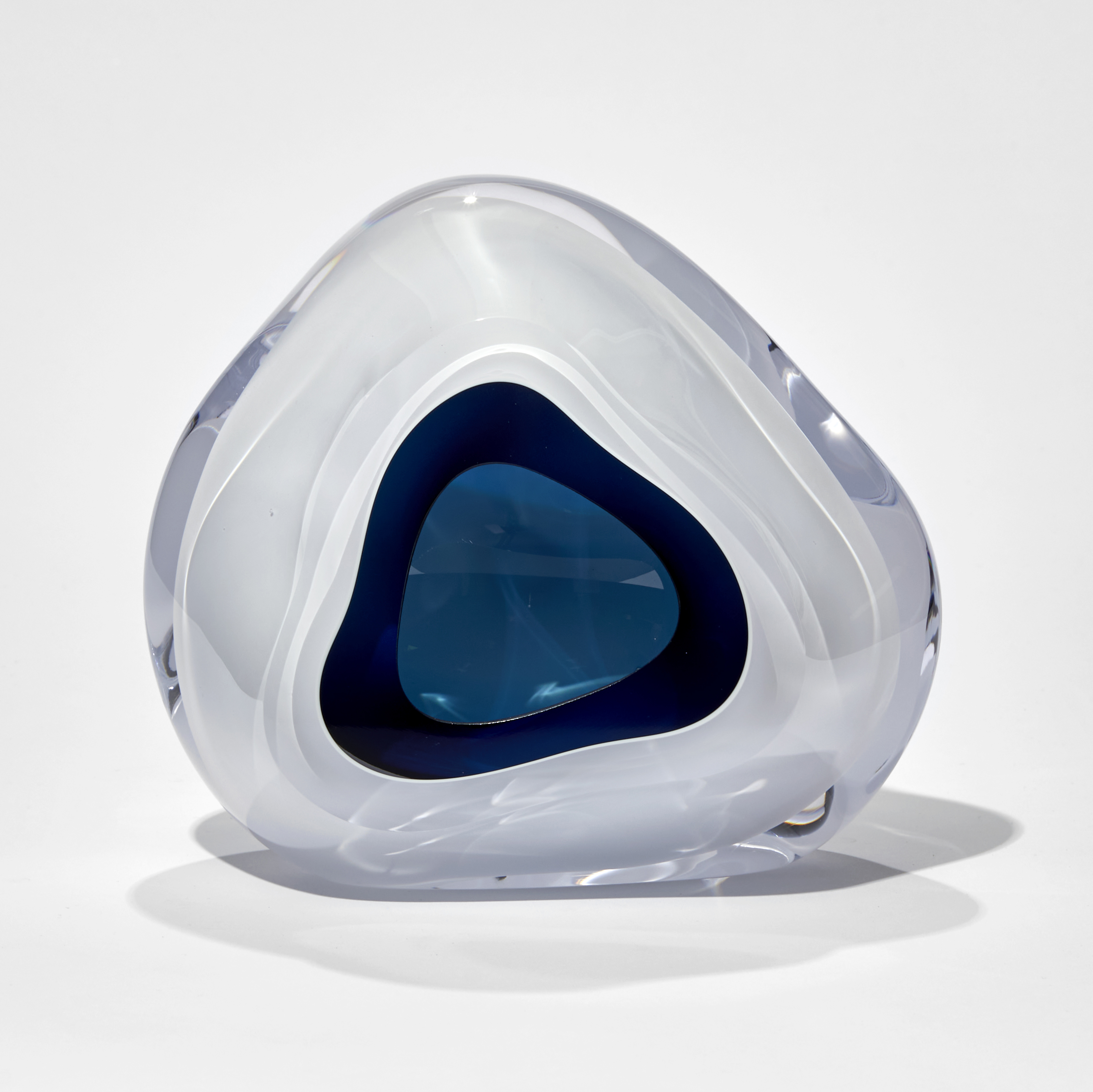 white and dark turquoise soft triangular sculpture with central aperture hand made from glass