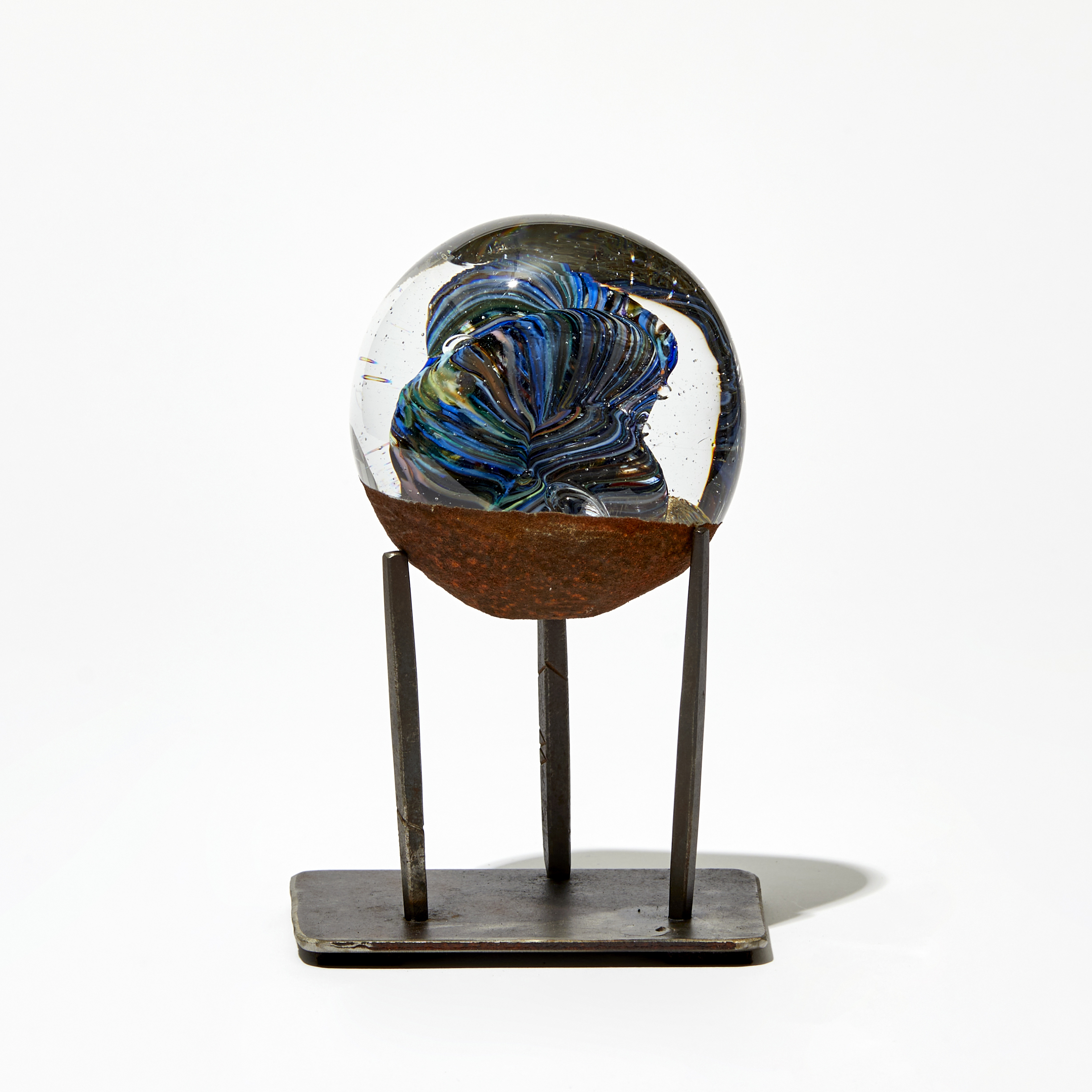blue clear and brown meteorite round glass sculpture on steel pronged base