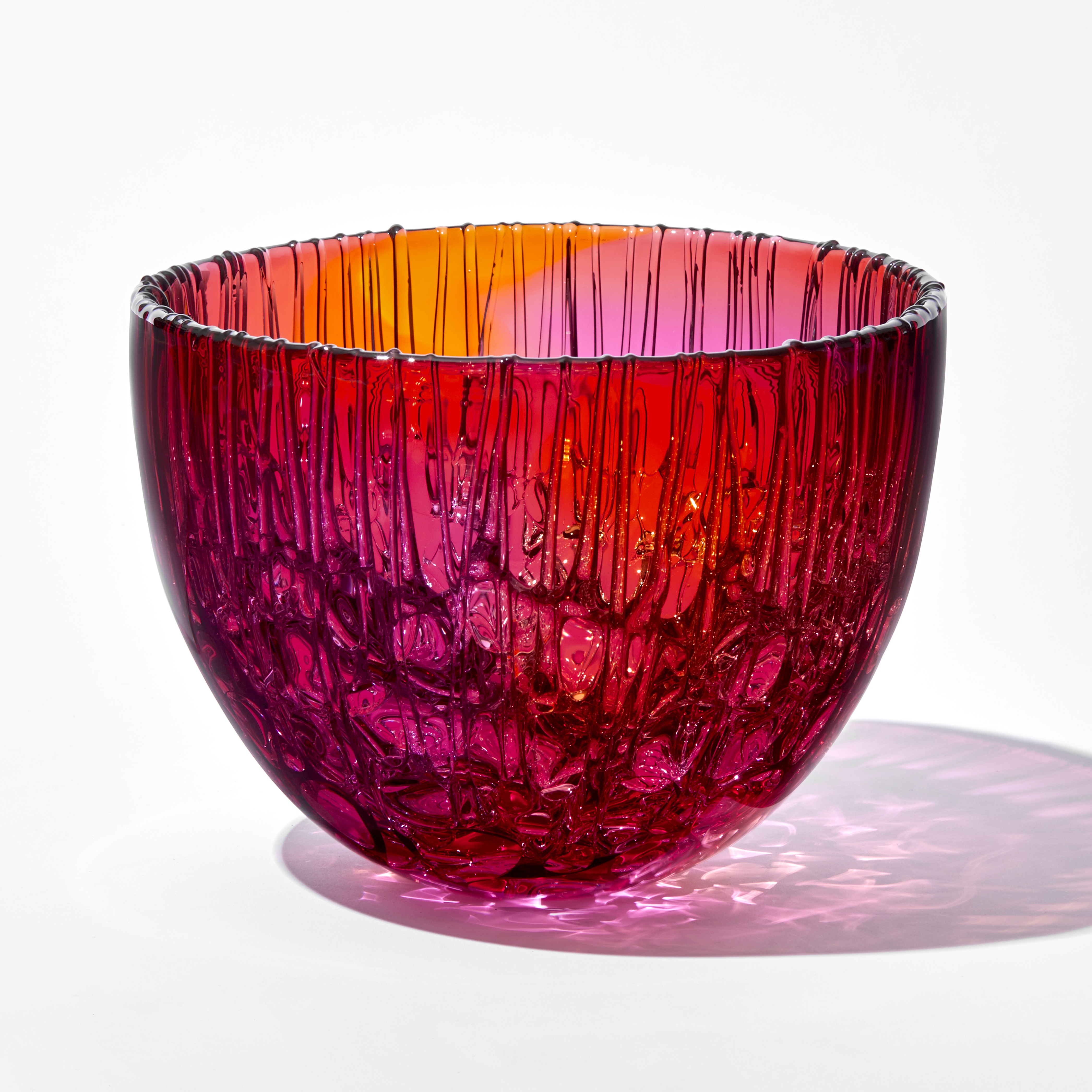 bright pink and amber round curved bowl with dribbled pooled internal texture handmade from glass