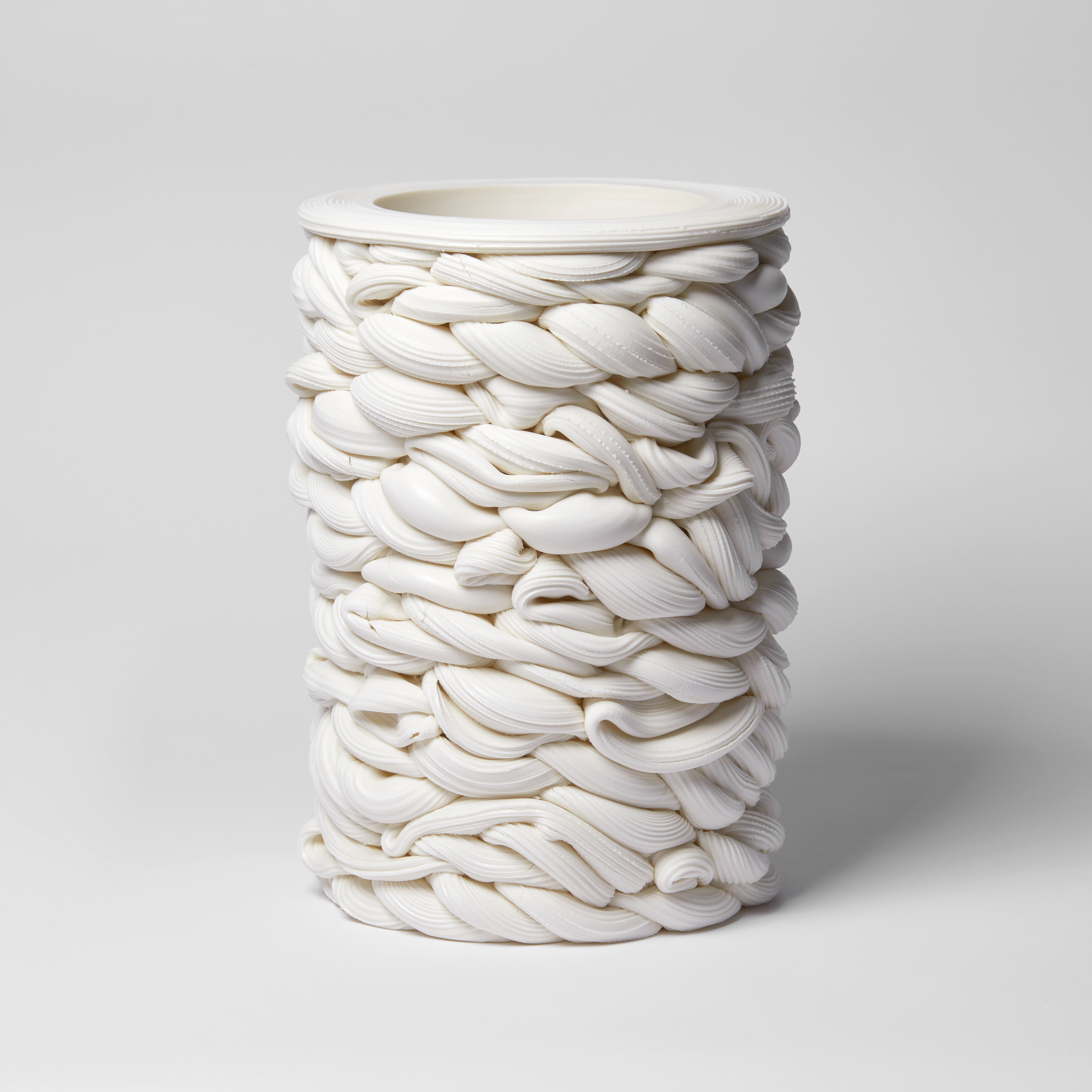 a cylindrical vessel of white thick twisting interwoven lines hand made from parian porcelain