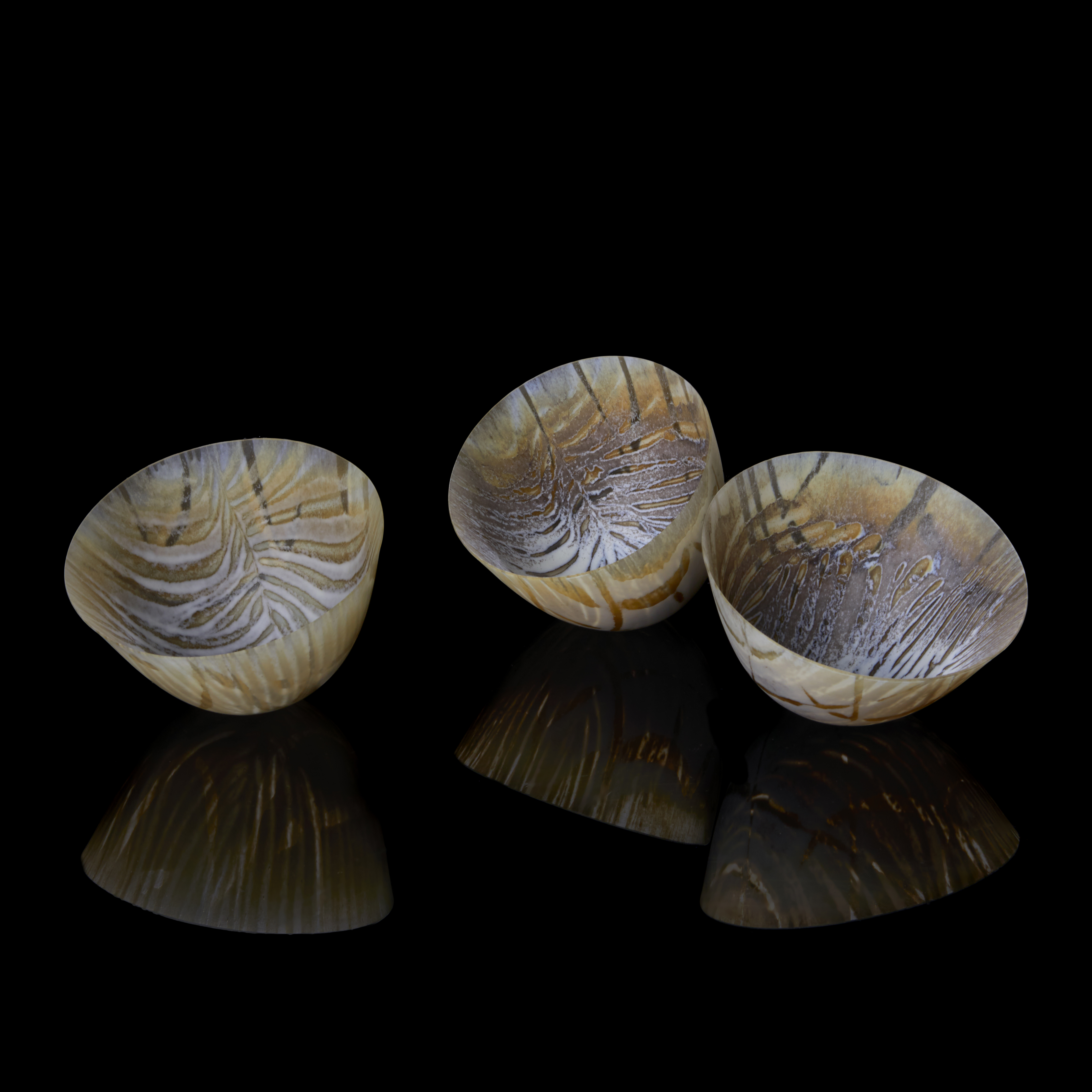 white and autumnal coloured small bowls with rounded base and internal feather texture hand made from glass