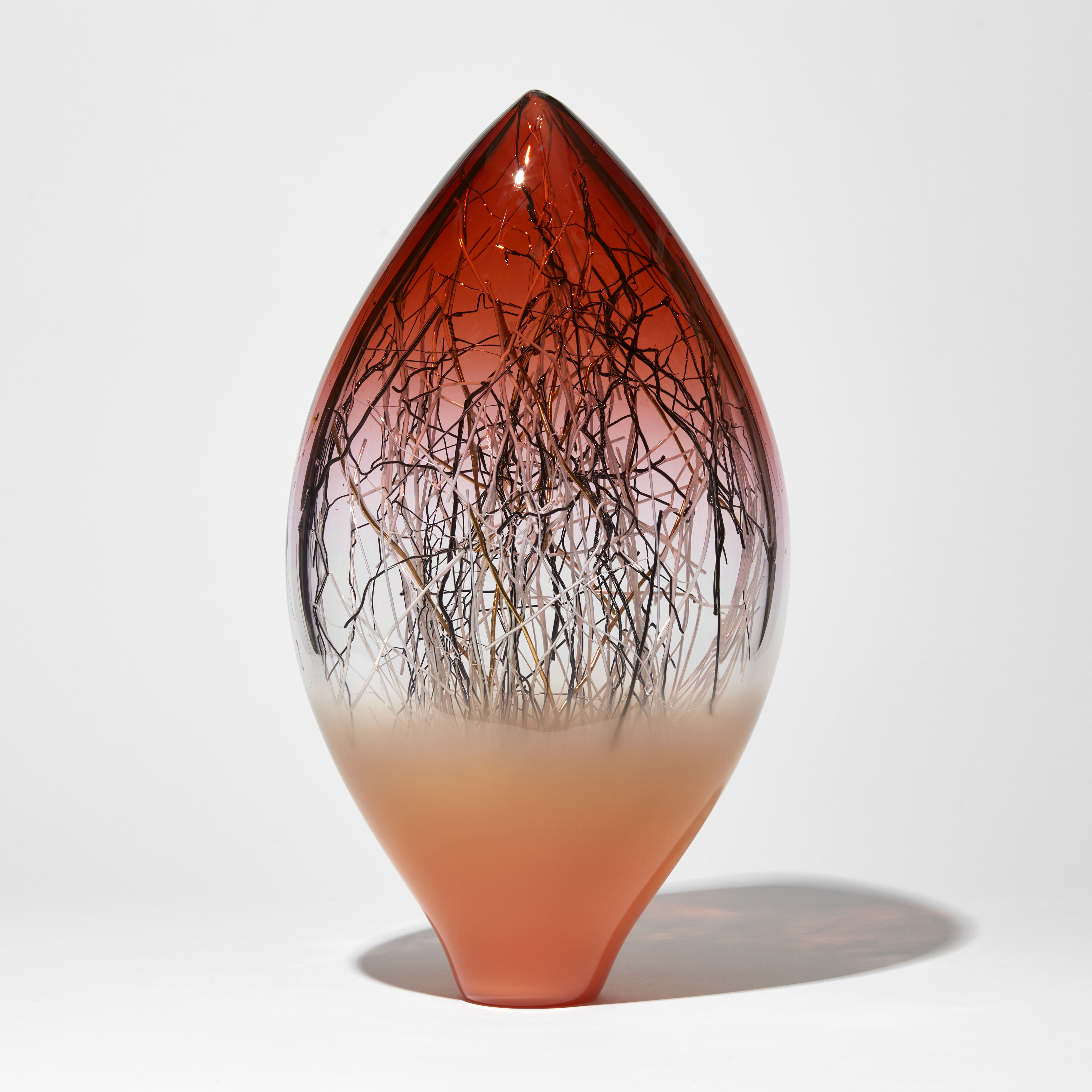 ruby red salmon orange and clear teardrop shaped artwork with internal fine canes in black white and gold handmade from glass