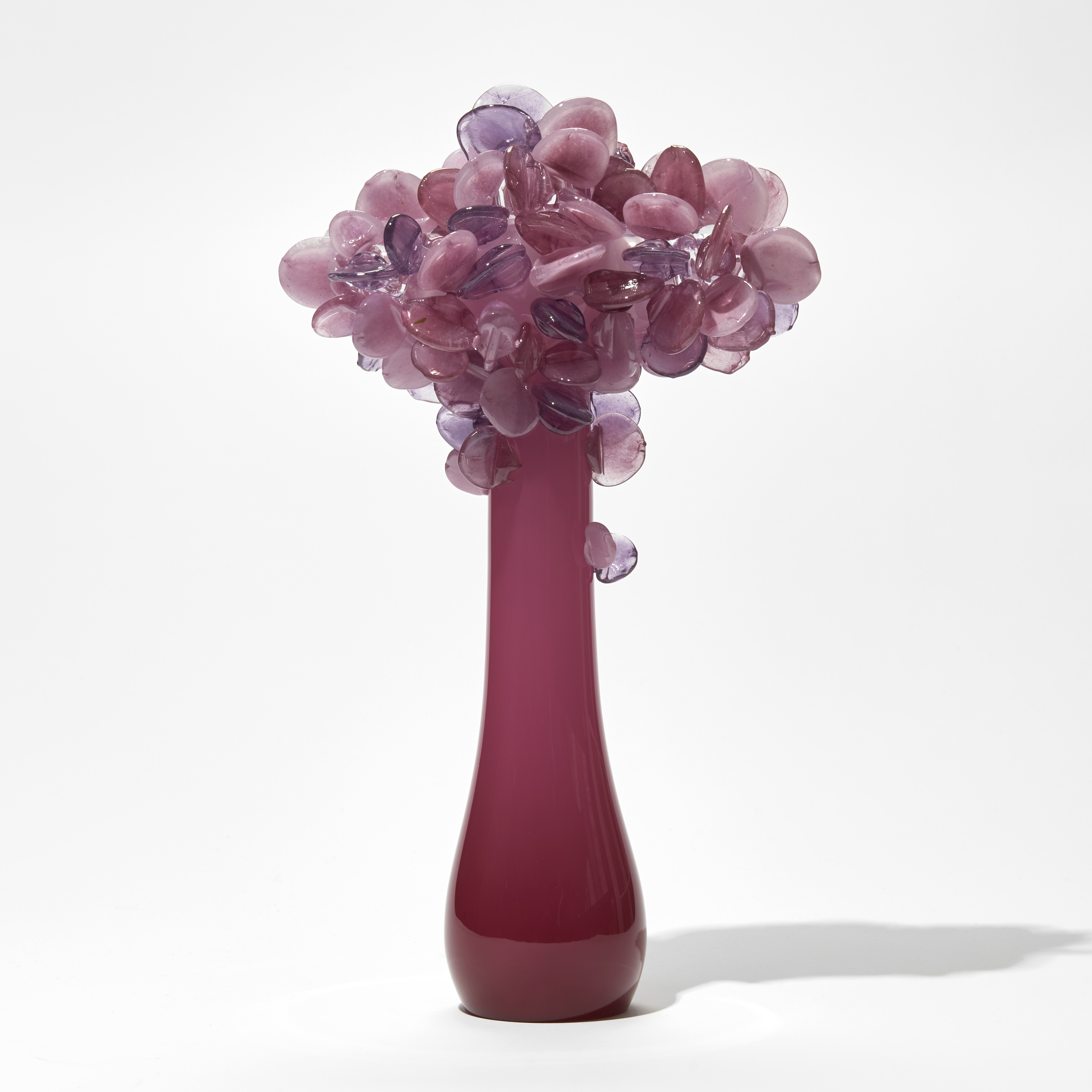 deep pink sleek stylised trunked tree sculpture with lollipop leaves in pink hues hand made from glass