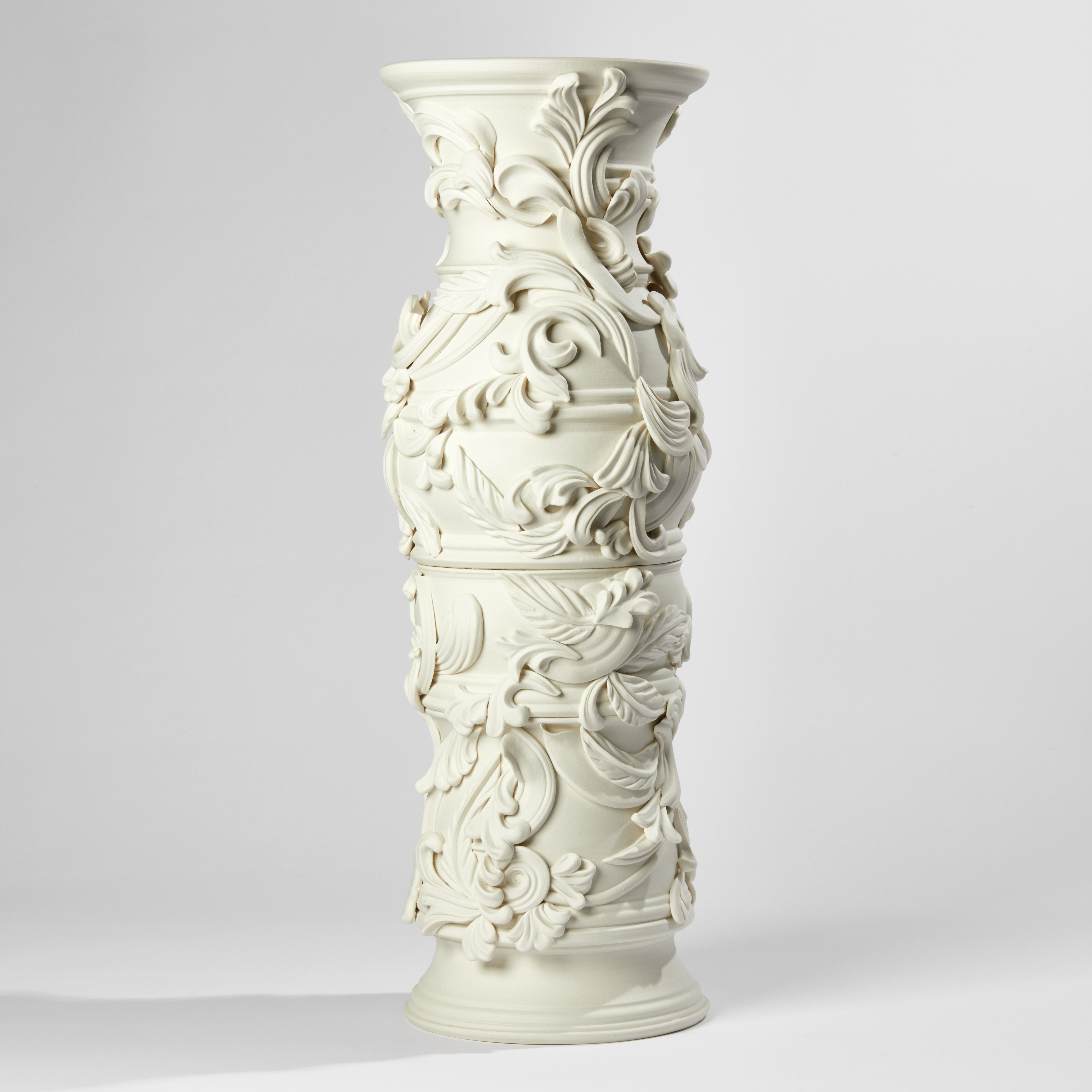 white undulating column with organic flourishes and relief swirl details handmade and thrown from porcelain
