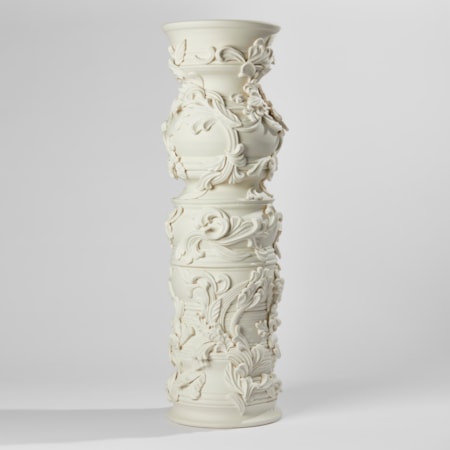 statuesque porcelain column covered in organic flourishes and relief leaf like swirling detail