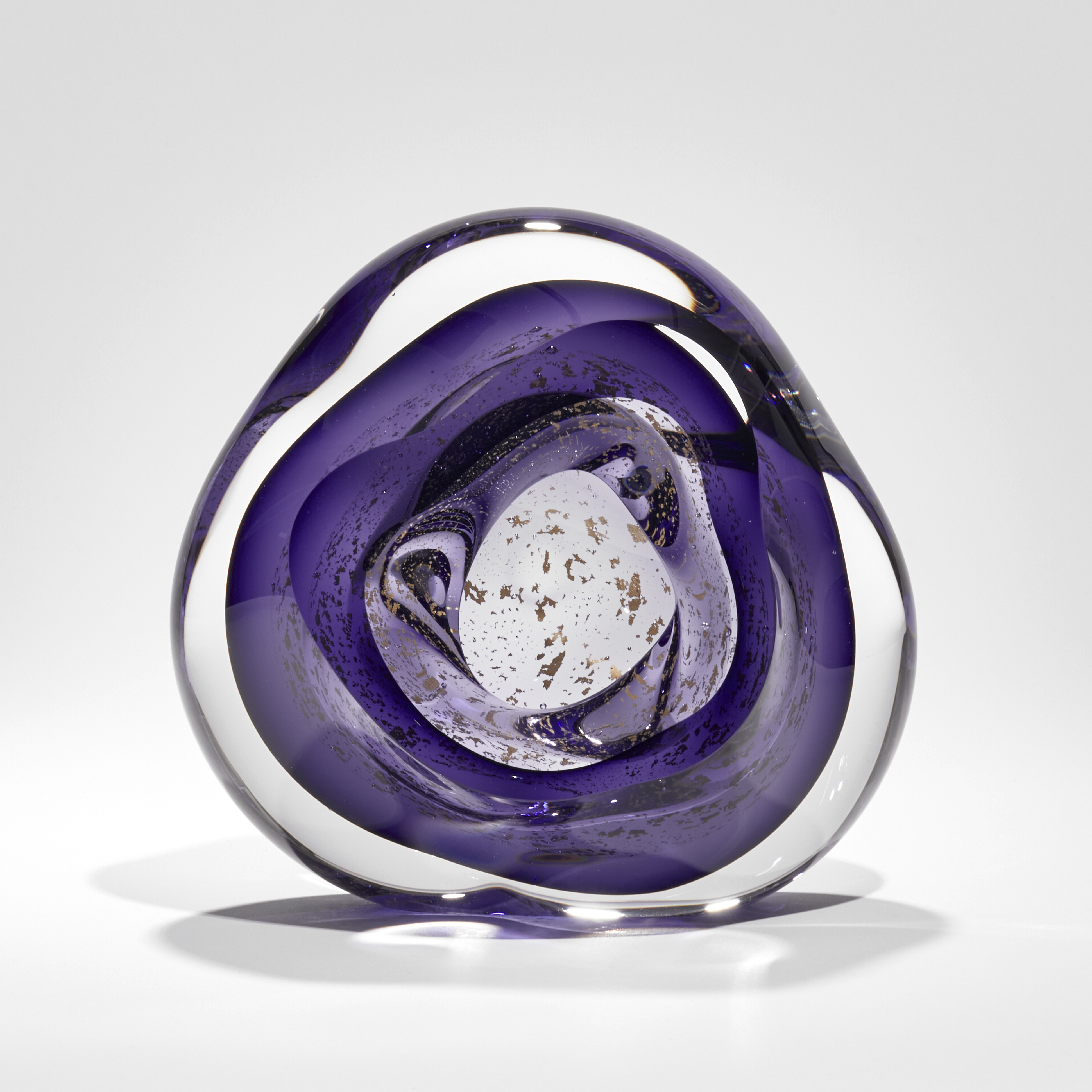soft rounded clear and rich purple hand blown glass sculpture with floating gold leaf elements