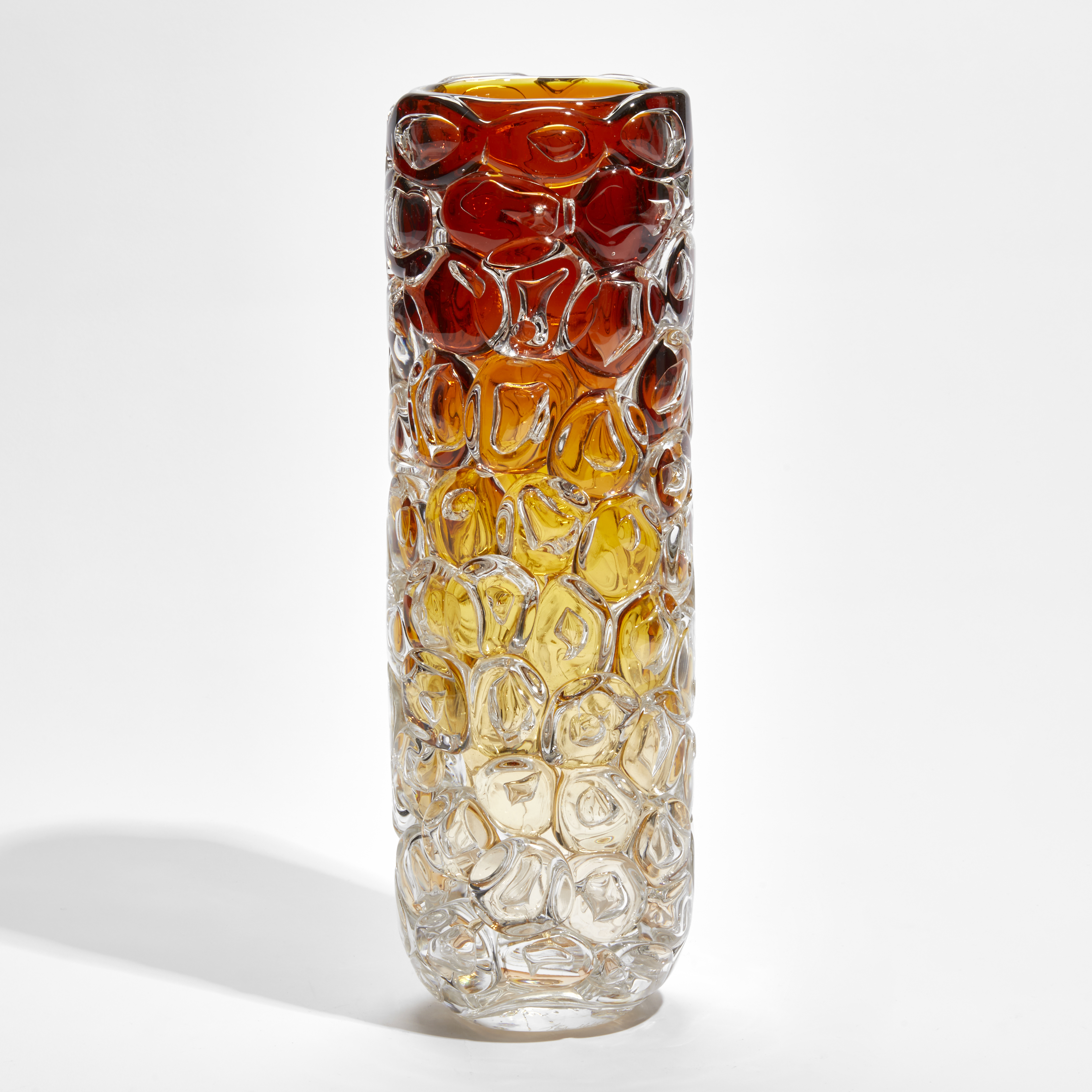 cylindrical vase fading upwards from clear yellow to amber appearing as if made from stacked oversized bubbles handmade from glass