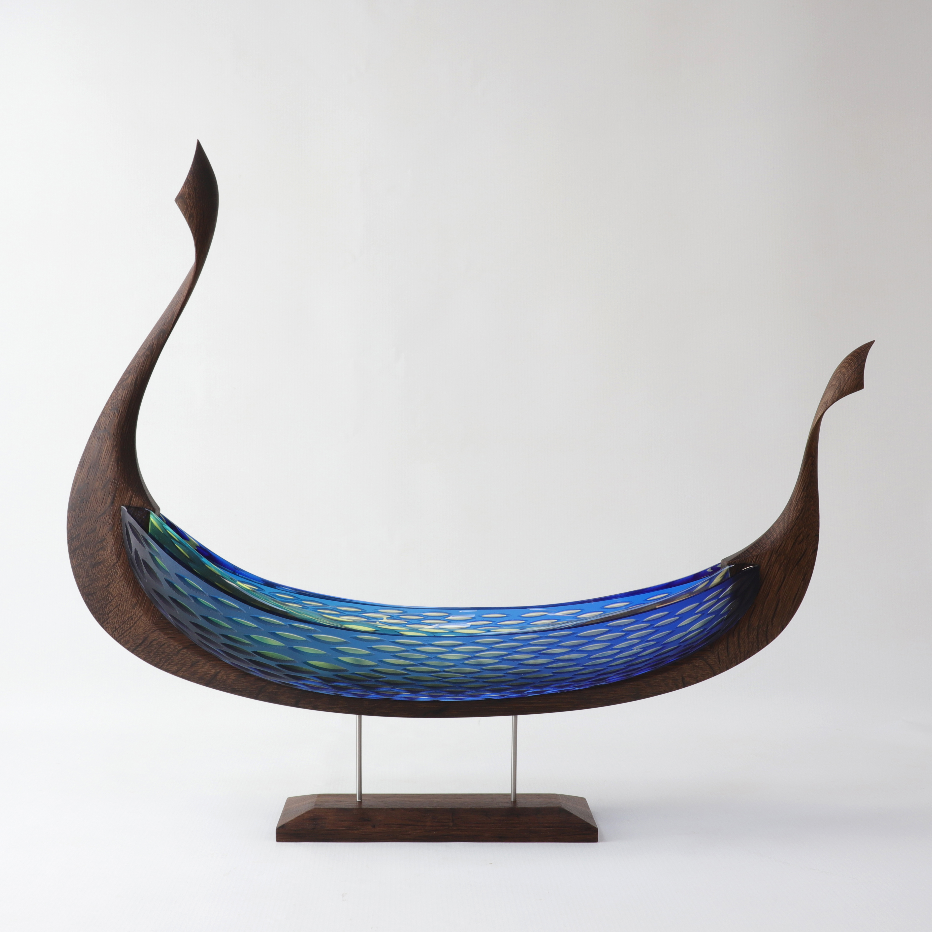 brown green and blue rounded hulled ship with textured hull created by hand in glass and wood