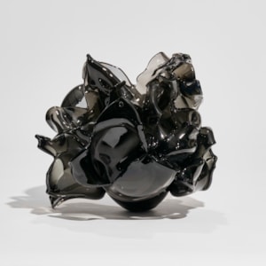 black flower vase with petals in different abstract organic shapes attached to a ovoid base hand made from glass