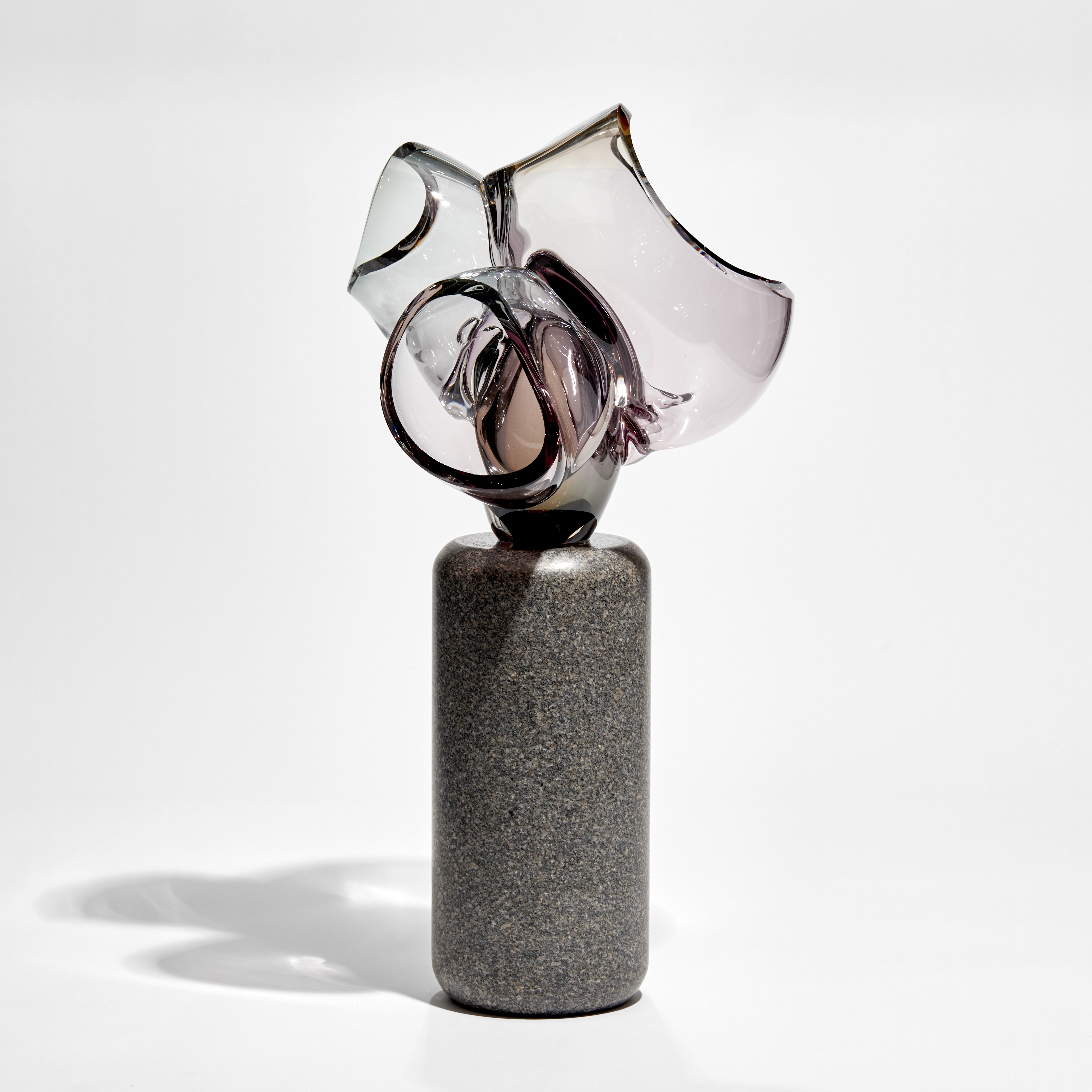 abstract floral sculpture with column of dark grey stone base with transparent purple pink cut bubbles on top